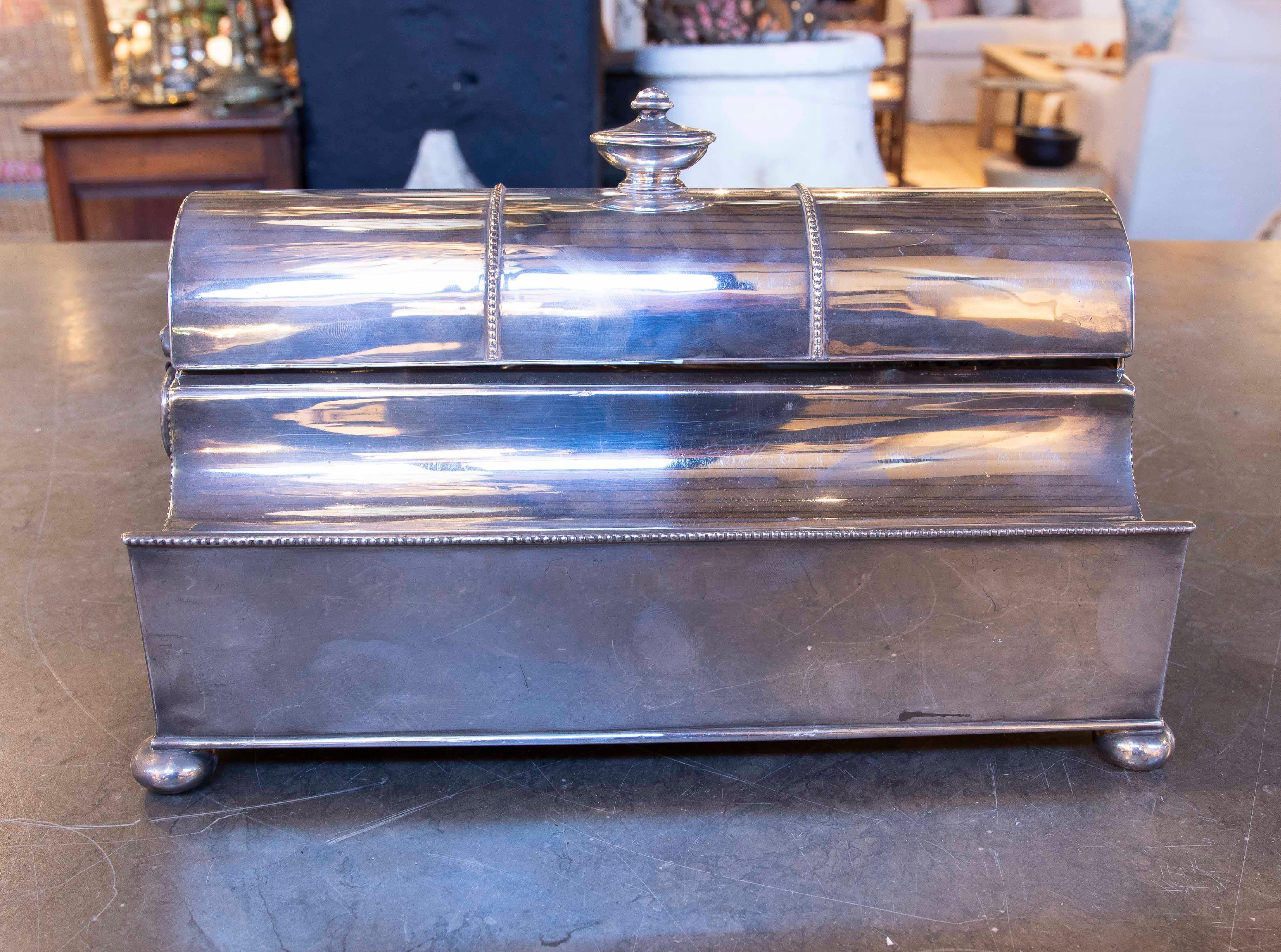 Desk inkwell in the shape of a chest, made of brass with a functional design. When opened, it reveals compartments that include crystallized ink bottles, a writing palette with a glass lid, and a silver-plated blade with distinctive marks and