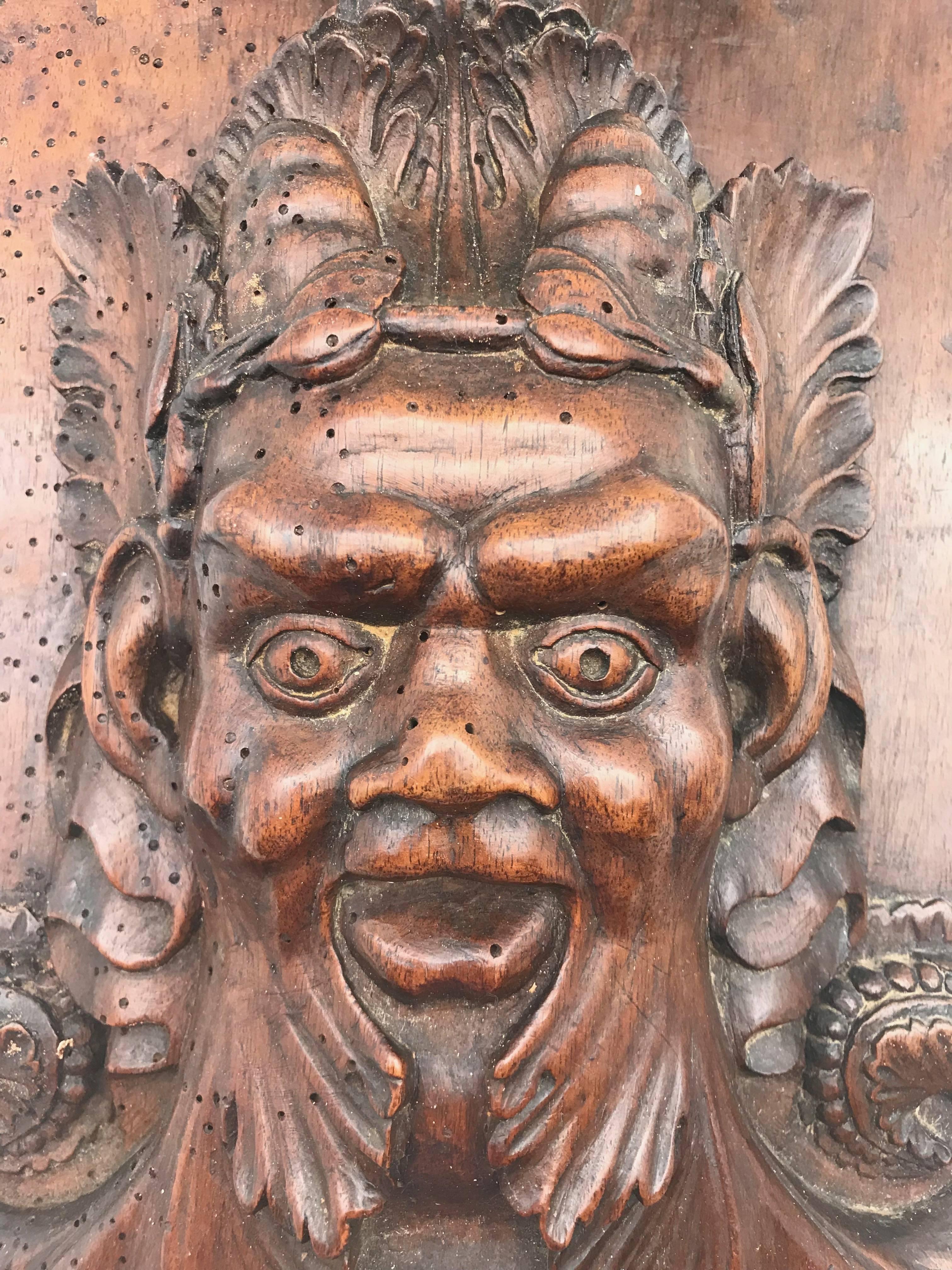 Beautiful study of a carved wooden head of Bacchus on a panel with grapes and fruits, date carved 
