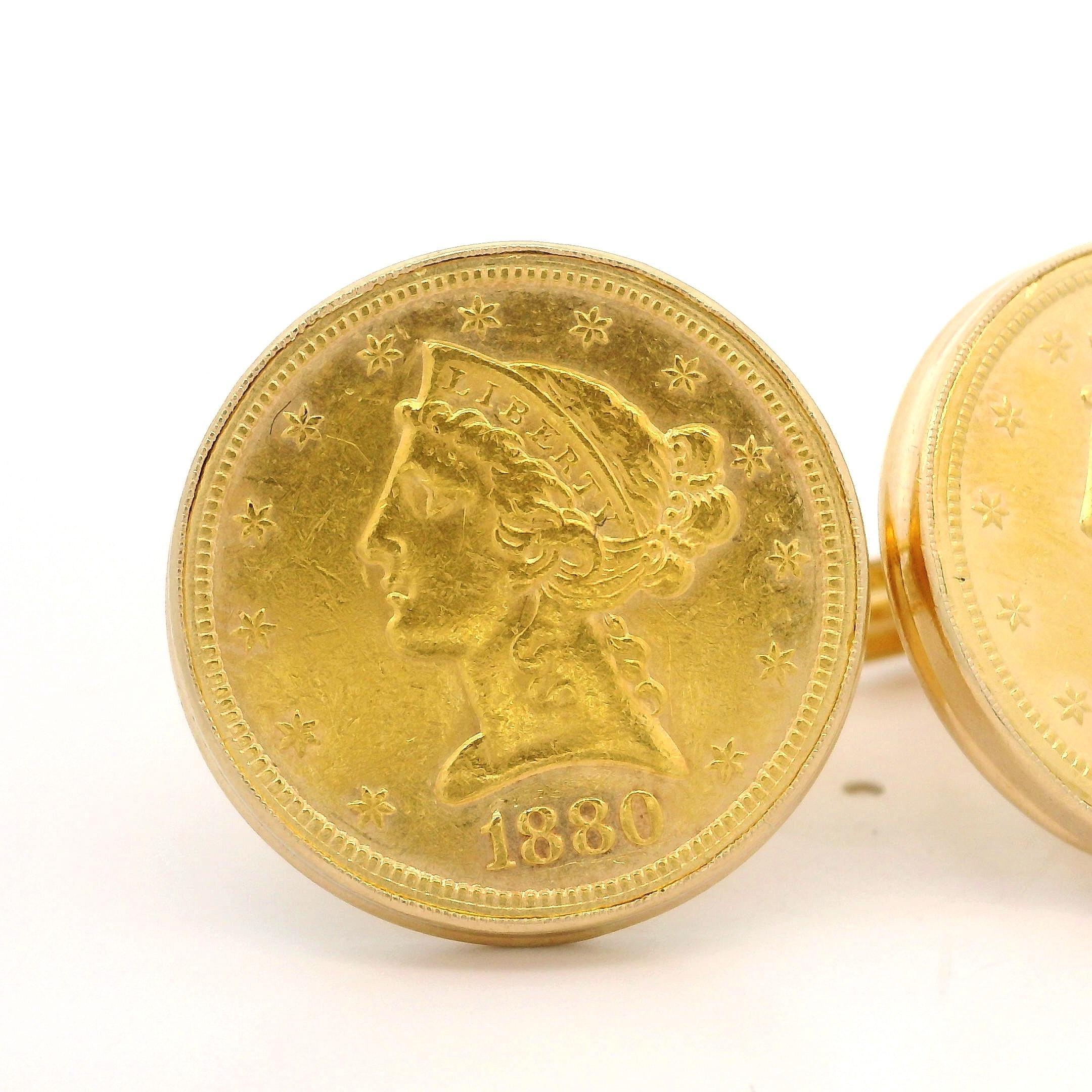 MATERIAL : Cadre : or jaune 14k - Pièces : Pièce de 5 dollars en or massif .900 Liberty Coin 1878-1880-S
Poids brut : 25,17 grammes
Diamètre du panneau : 22,9 mm (0,90 pouce)
Espace entre les panneaux : 13,3 mm (0,52 pouce)
Support : Dos