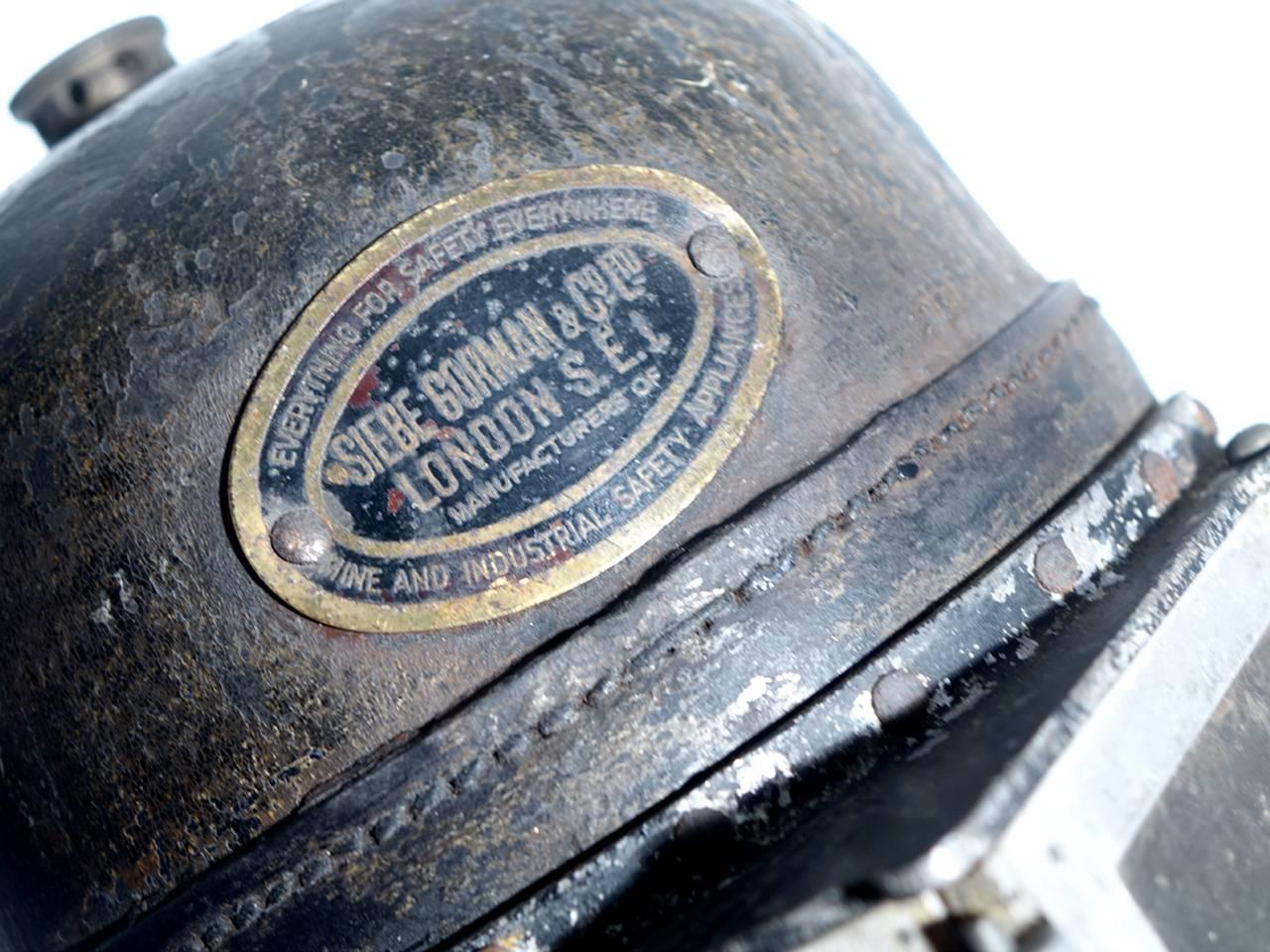 This is an early Siebe Gorman smoke mask. These full face helmets are very rare and found mostly in museum collections. It's signed on a brass plaque. Manufactured by Siebe Gorman and Company, London, England. The front has doors that swing open and