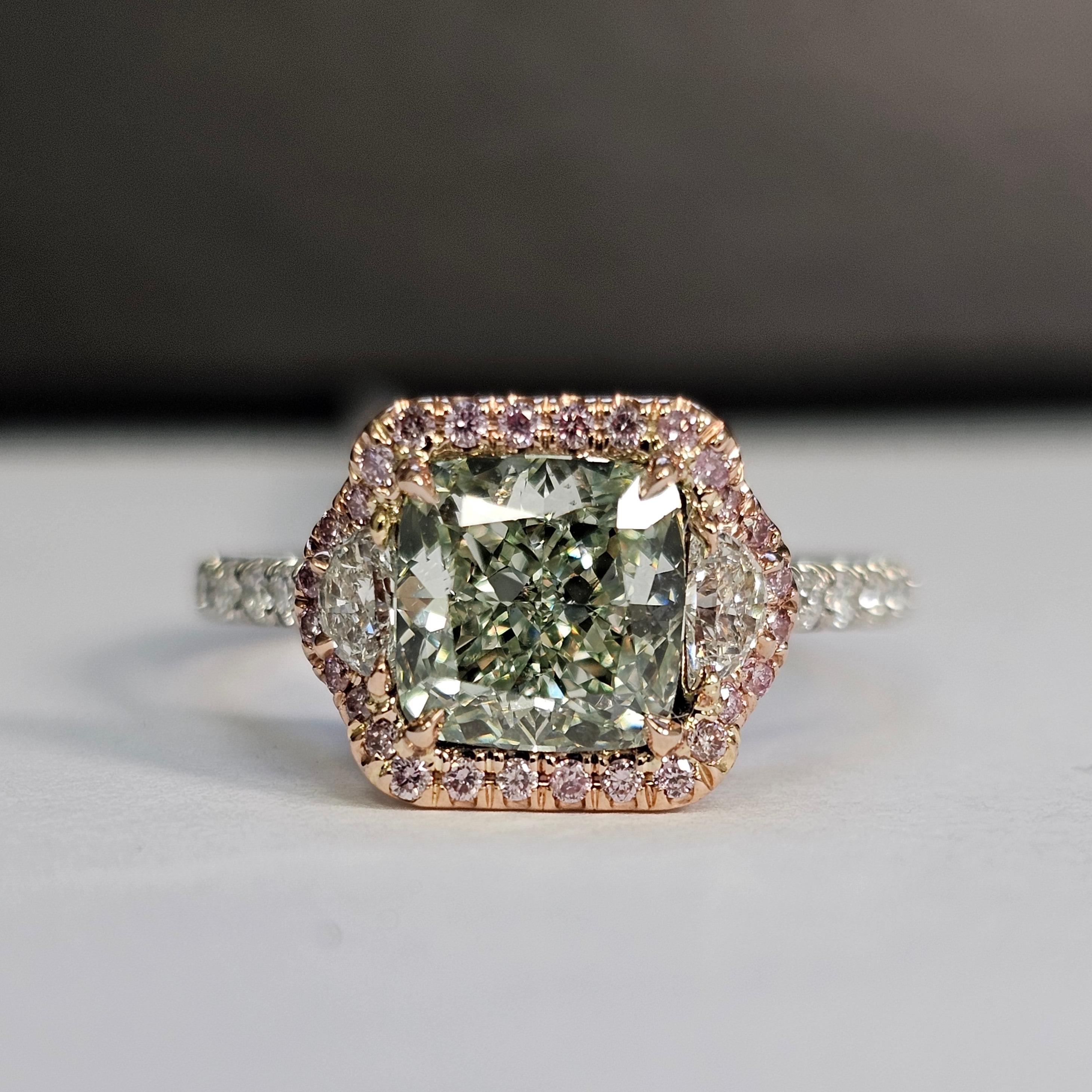 Gorgeous lime green colored diamond graded Fancy Yellowish Green, square cushion
Set in a Platinum and Rose Gold Ring with Fancy Intense Pink diamonds surrounding the center stone along with colorless half moons, breathtaking ring
Green diamonds