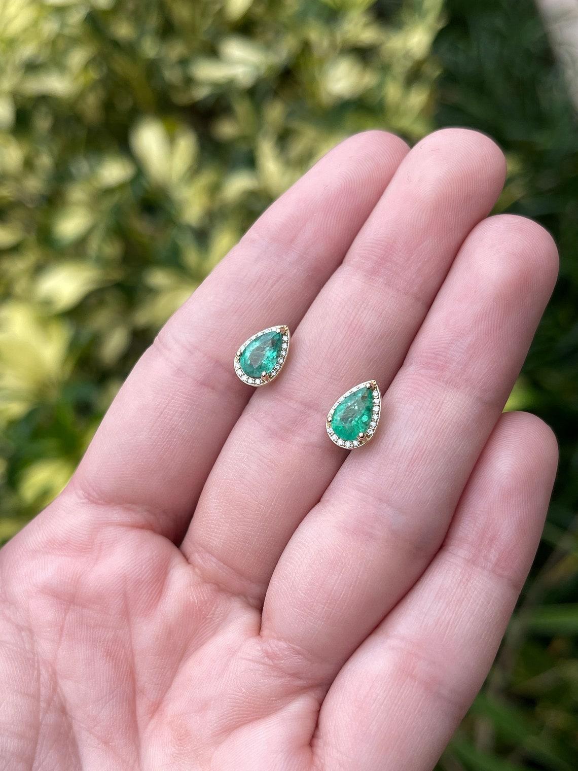 Voici un magnifique ensemble de boucles d'oreilles en or jaune 14 carats composé d'émeraudes en forme de poire et de diamants VS. Les émeraudes extraites de la terre, d'une transparence incroyable, sont mises en valeur par un halo de diamants pavés.