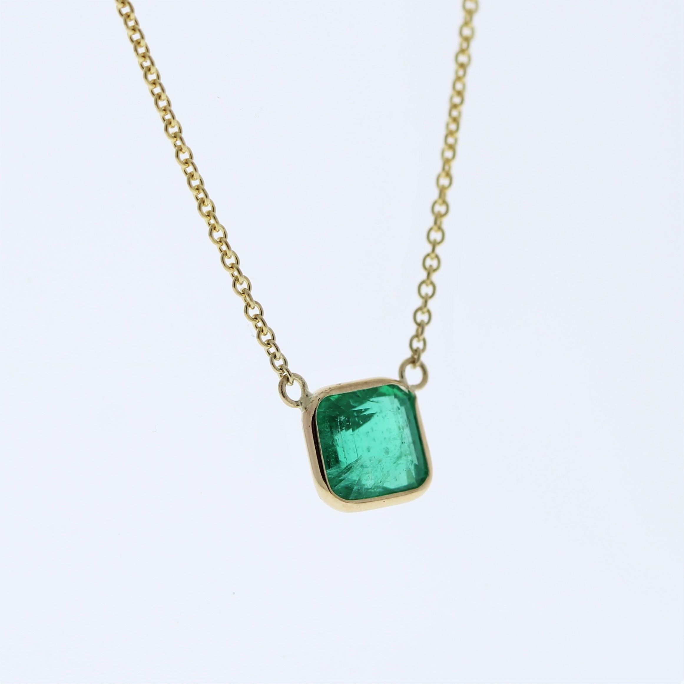 The necklace features a 1.88-carat Asscher-cut emerald set in a 14 karat yellow gold pendant or setting. The Asscher cut and the lush green color of the emerald against the yellow gold setting are likely to create an elegant and eye-catching fashion