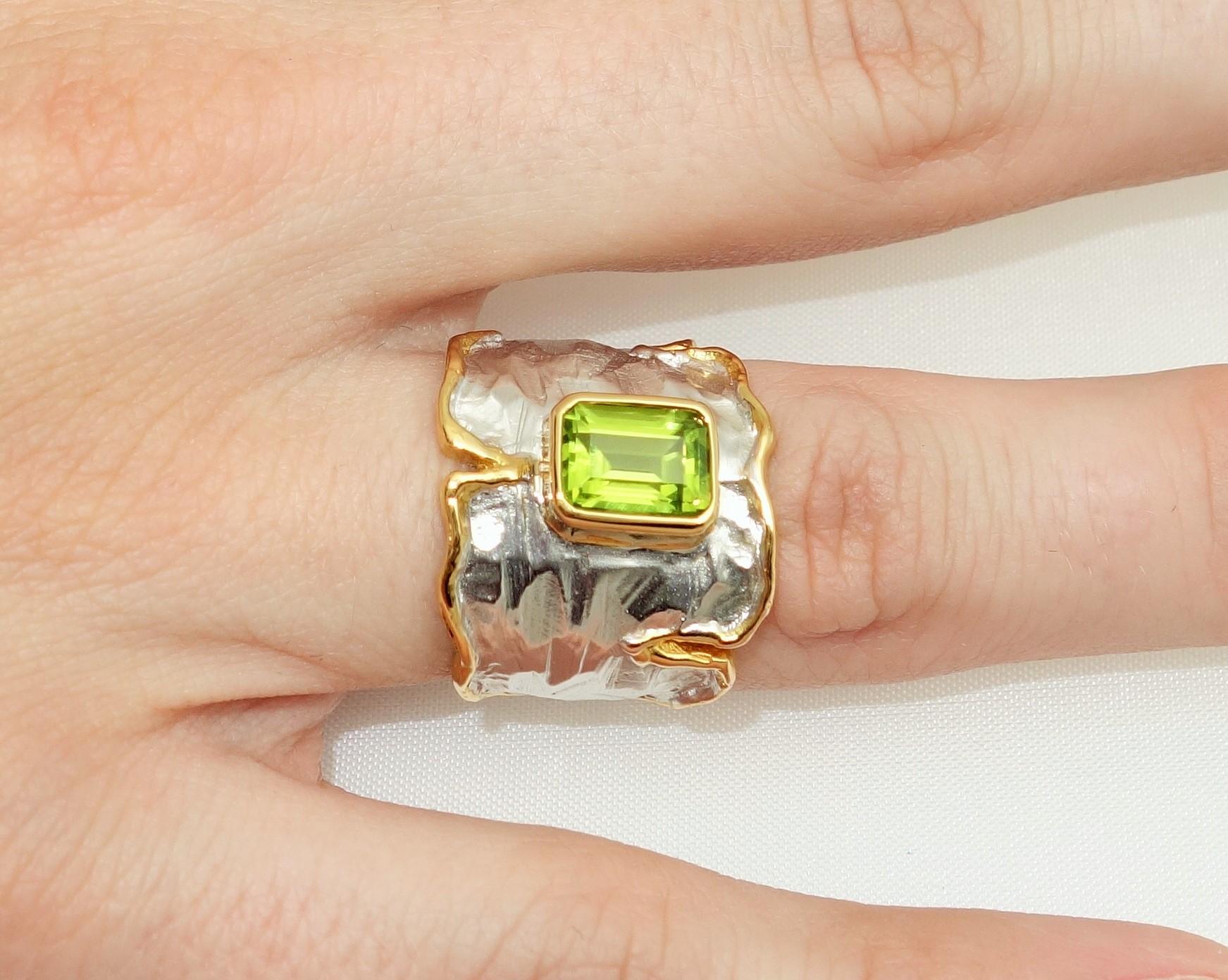 Stunning Solitaire Ring featuring a 1.88 Carat Rectangular Peridot Gem stone. Sterling Silver Tarnish-resistant and 14K Gold border. Beautifully worked mounting Ring Size 7. Classic and Classy…illuminating your look with Timeless Beauty! 
