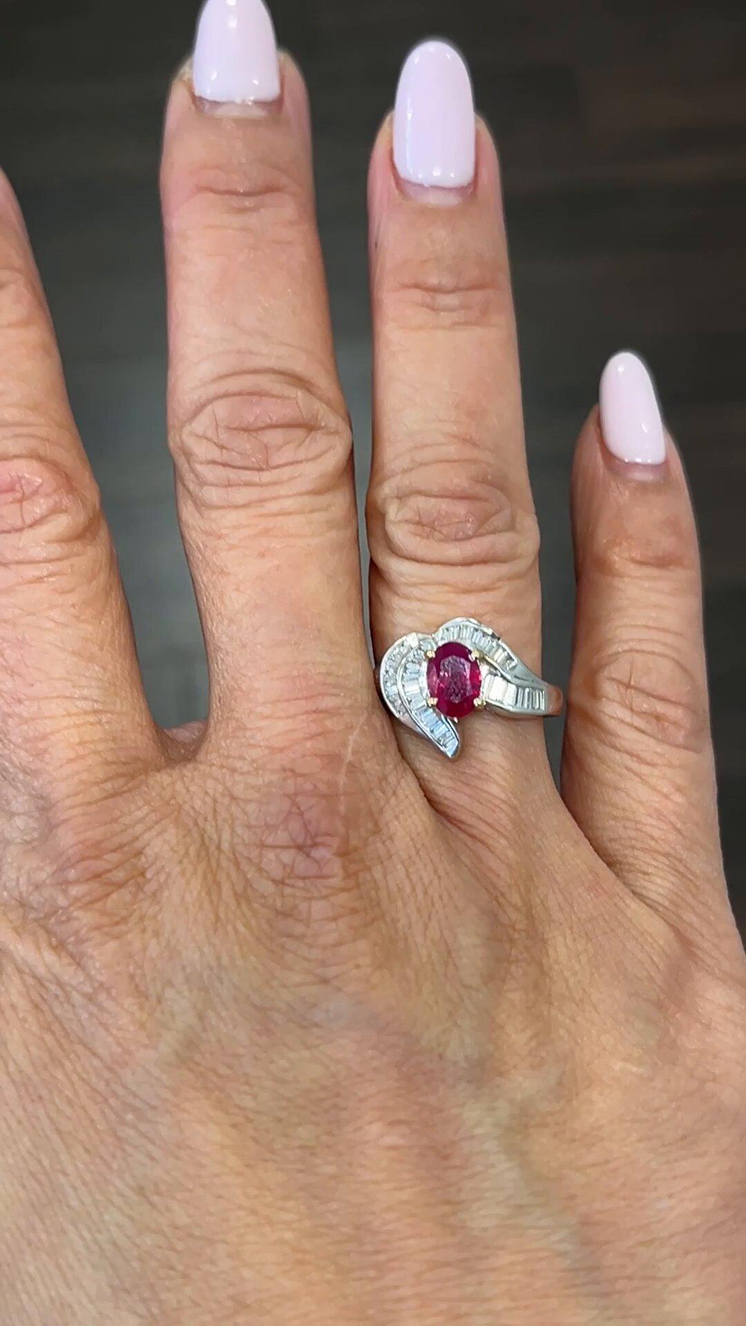 Elevate your style with this stunning ring featuring a vibrant red oval-shaped ruby gemstone weighing 0.98 carats. The eye-catching gemstone is surrounded by sparkling diamonds, adding to the glamour of this piece. Crafted in 18k white gold, this