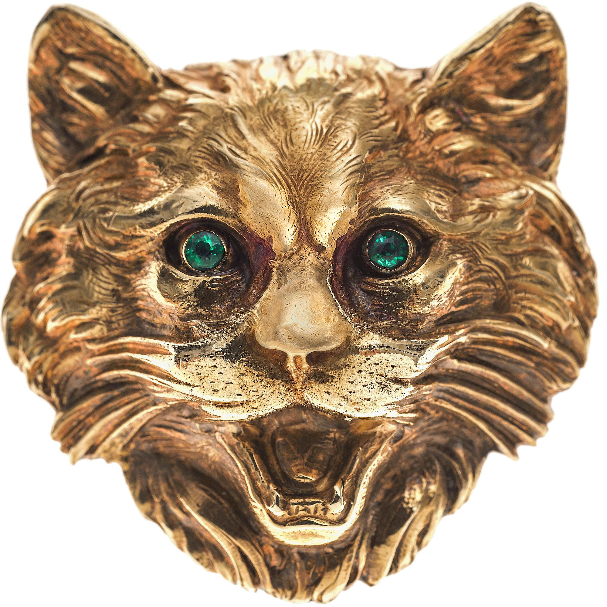Broche naturaliste très expressive d'une tête de chat avec deux yeux en émeraude facettés. La fourrure du chat est ciselée de façon naturaliste et gravée dans de l'or 18K rouge et jaune. Il y a une marque de contrôle française sur le crochet.