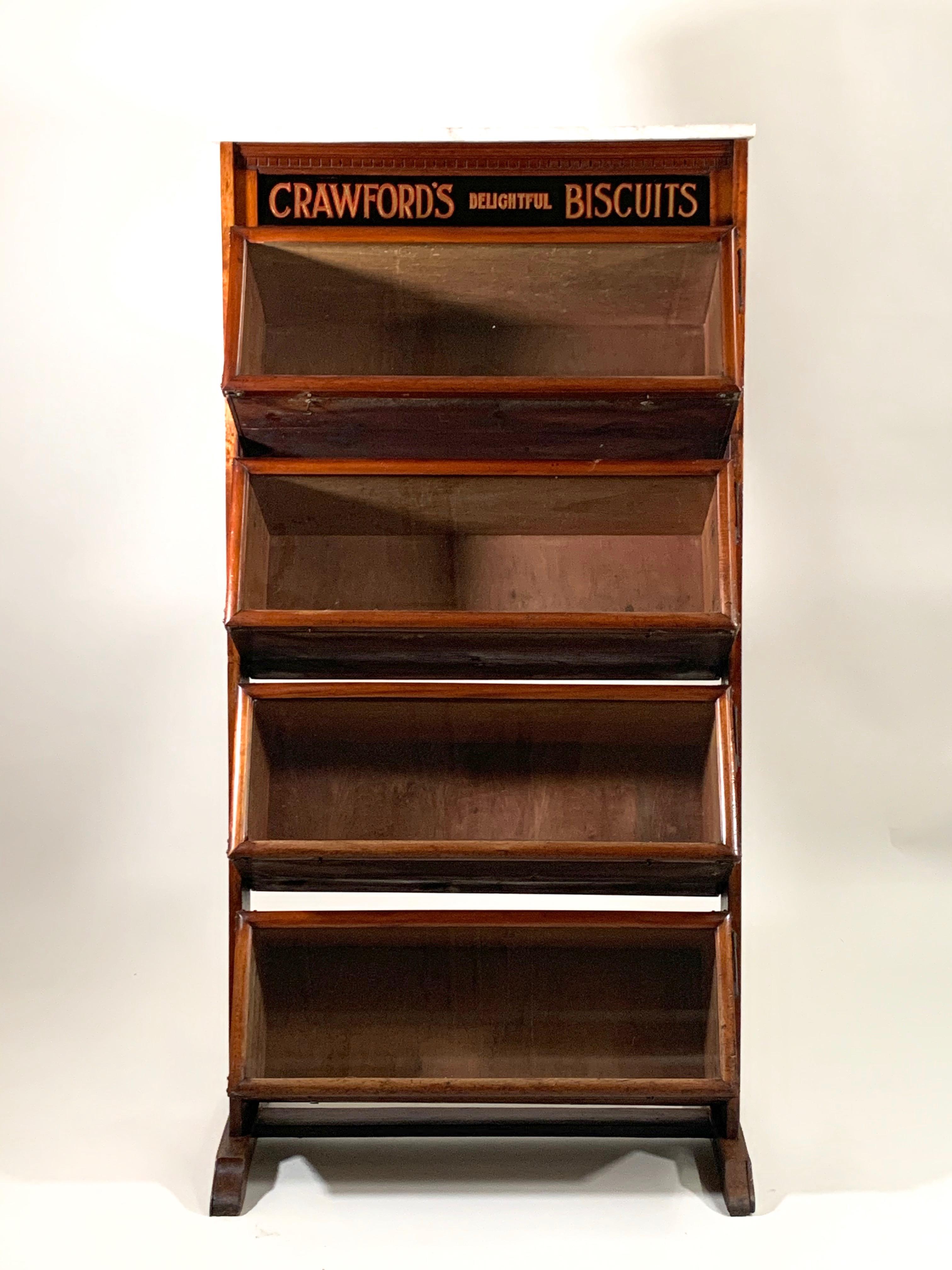 Circa 1880 Crawford's Delightful Biscuits mahogany floor standing store display cabinet. Has a white marble top with veining and reverse painted advertising on the glass. The three front glass cabinets have brass hardware. Manufactured by Taylor