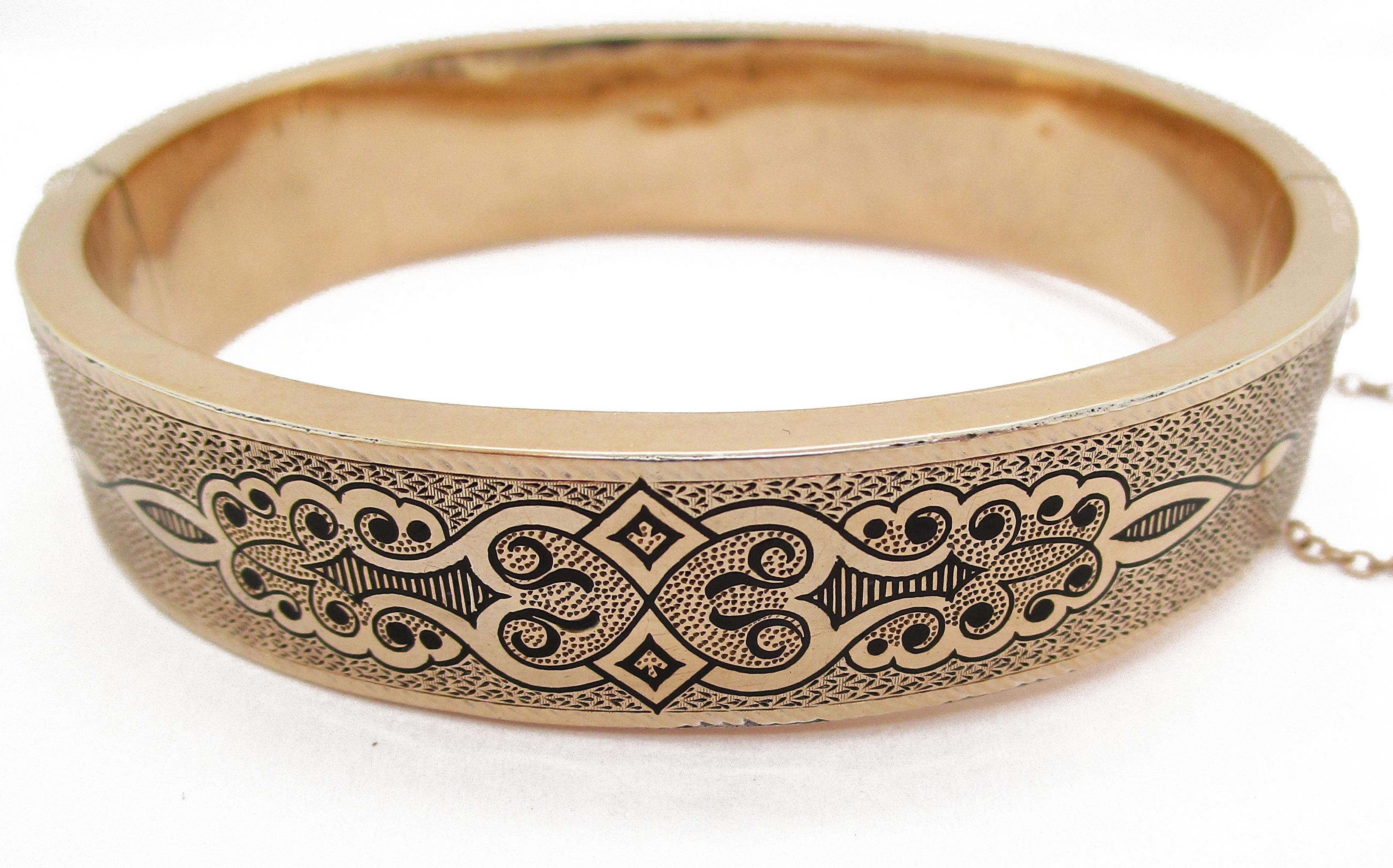 This stunning hinged Victorian bangle is in gorgeous 18k rose gold decorated with fine enameled details. With its wide, linear pattern, this bracelet makes a statement sitting on almost any wrist. The intricate, swooping enamel details add a touch