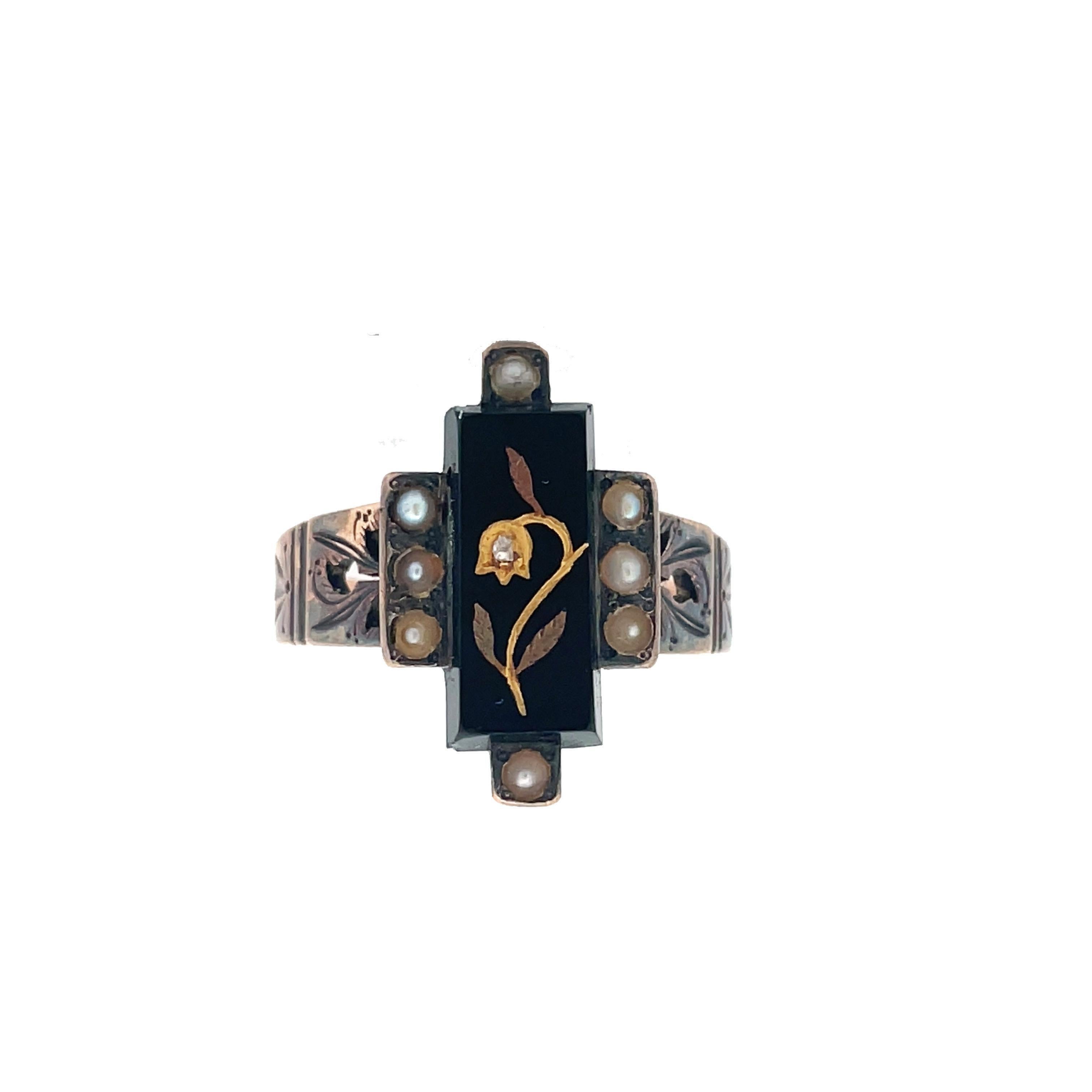 This is a spectacular Victorian ring crafted in 14K Rose Gold showcasing a rectangular black-onyx tablet adorned with seed pearls and a gold flower inlay with a sparkling diamond! A beautiful rectangular tablet of onyx is embellished with a flower