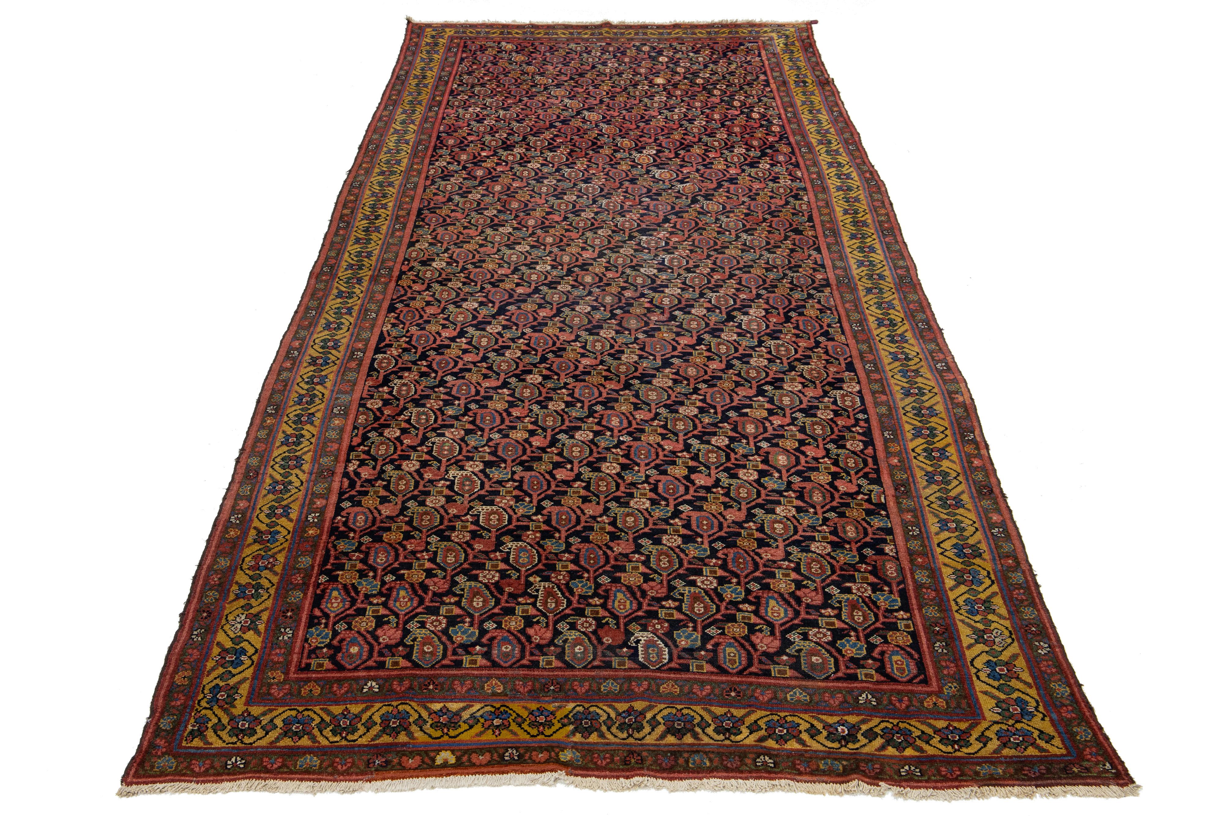 Ce magnifique tapis persan Malayer du XIXe siècle, fait à la main, présente un fond bleu profond rehaussé de touches de verge d'or, de rouge et de bleu tout au long de son dessin complexe.

Ce tapis mesure 6'5
