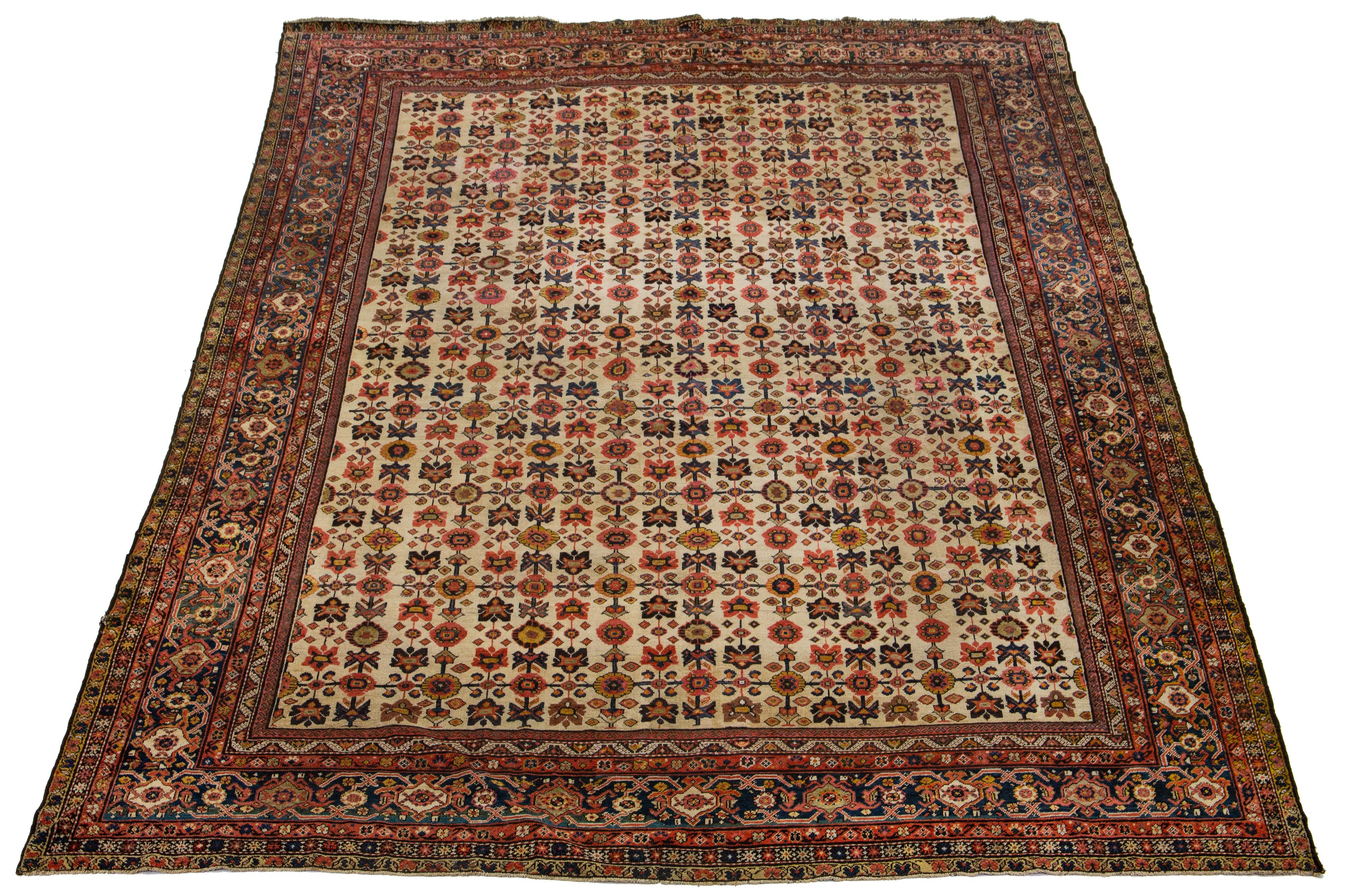 This is a beautiful Persian antique Farahan hand-knotted wool rug from the 1880s. It has a beige-tan color field and features classic multicolor accents in a floral pattern.

This rug measures 11'10