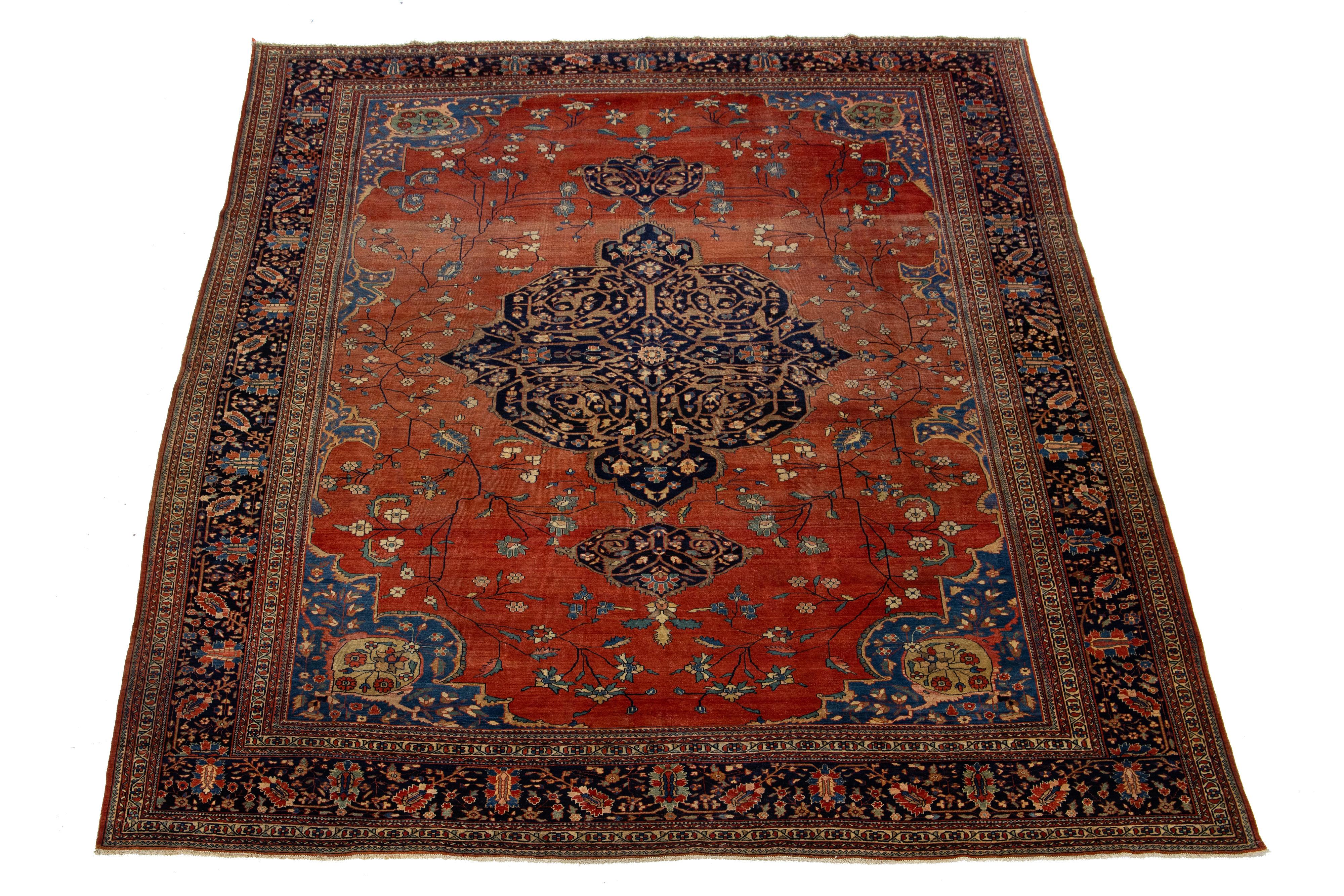Ce magnifique tapis persan Farahan en laine noué à la main date des années 1880. Son champ rouge-rouille est rehaussé de touches classiques bleu foncé dans un médaillon floral.

Ce tapis mesure 11'1
