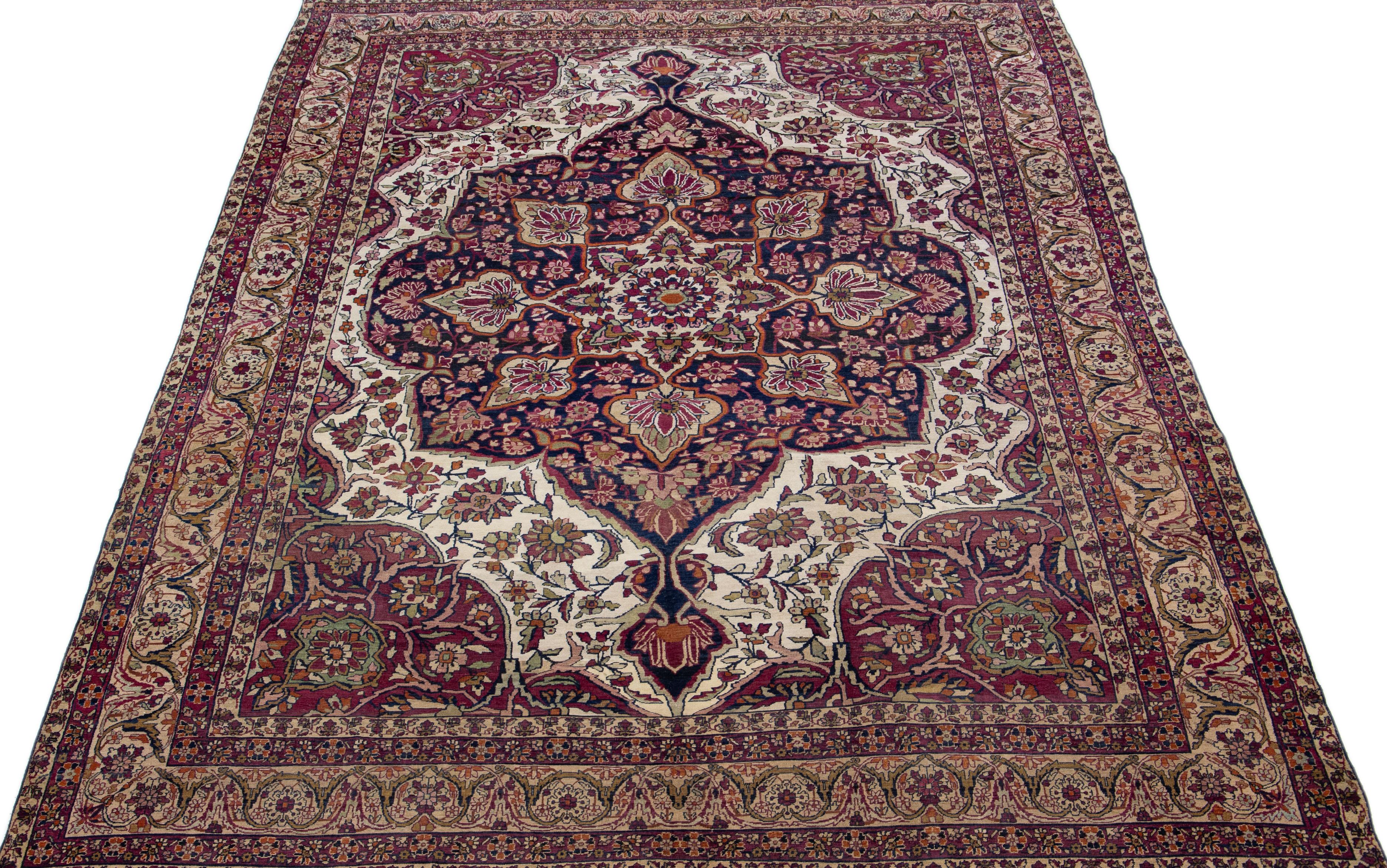 Beautiful antique Kerman hand-knotted wool rug with a burgundy color field. This Persian rug has multicolor accents in a gorgeous all-over medallion floral design.

This rug measures: 8'1