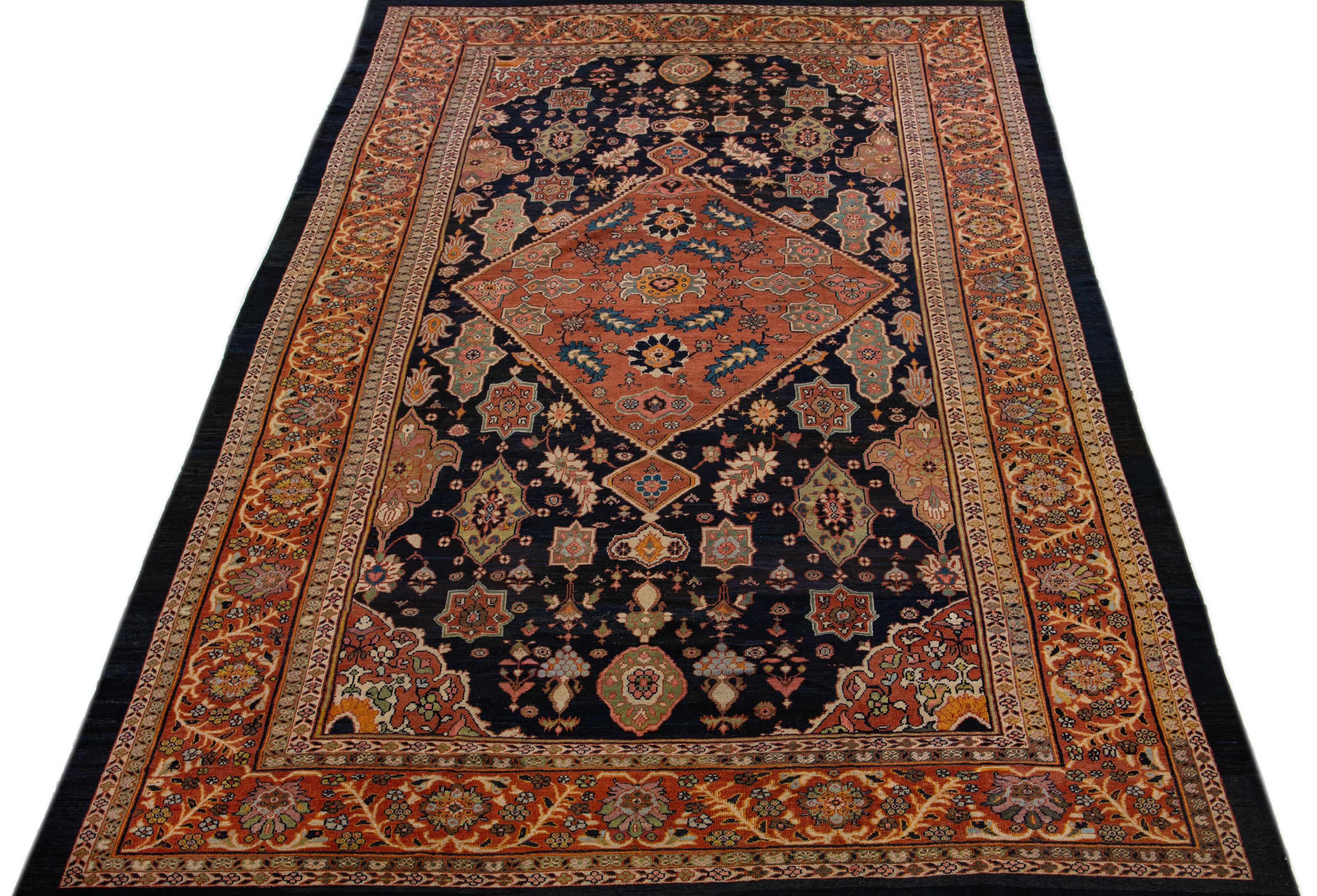 A stunning antique mahal wool rug, exquisitely hand knotted and endowed with a mesmerizing dark blue color field. This Persian masterpiece showcases a terracotta-designed frame that encases an all-over floral pattern, beautifully accentuated with