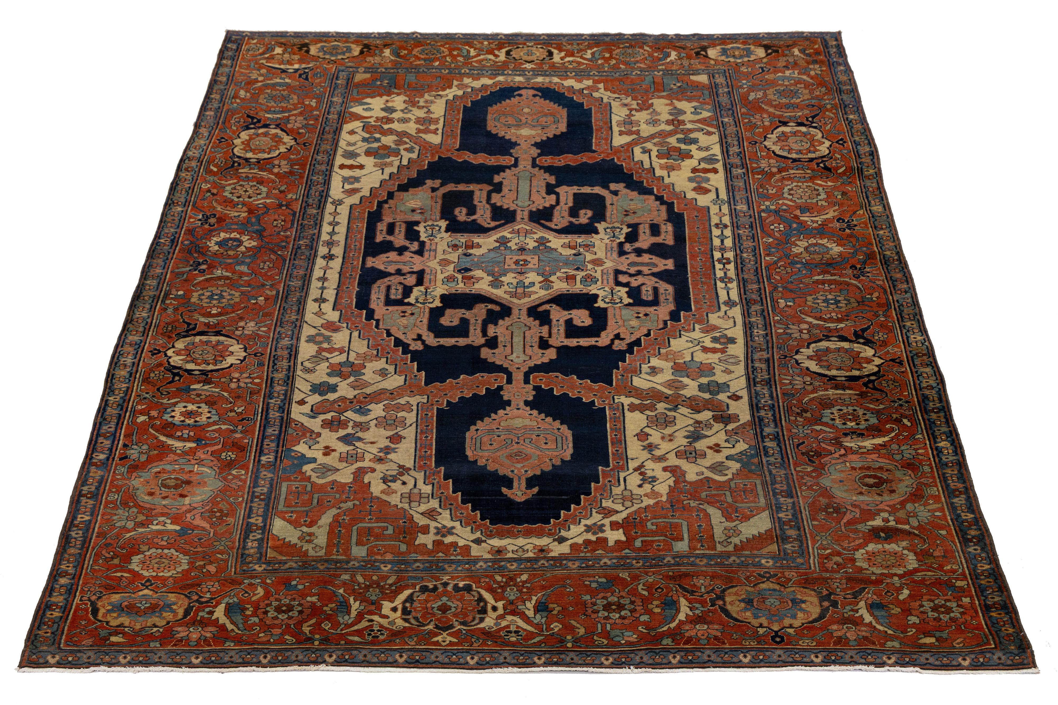 Dieser exquisite antike handgeknüpfte persische Serapi-Teppich ist ein zeitloses Zeugnis handwerklicher Meisterschaft. Vor einem Hintergrund aus warmem Beige und tiefem Marineblau verankert das markante zentrale Medaillon das Design mit königlicher