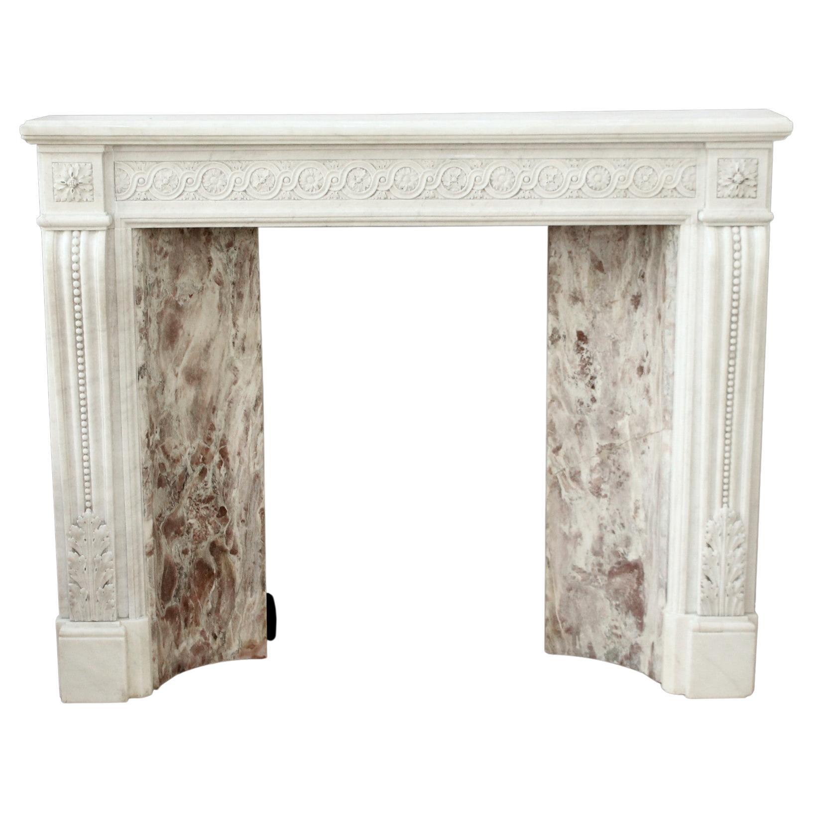 Petite antique 1880s white Victorian Carrara marble mantel with decorative hand carved floral details. Features beading on the legs and acanthus leaves on the bottom. Includes the original multicolored insert shown. Please note, this item is located
