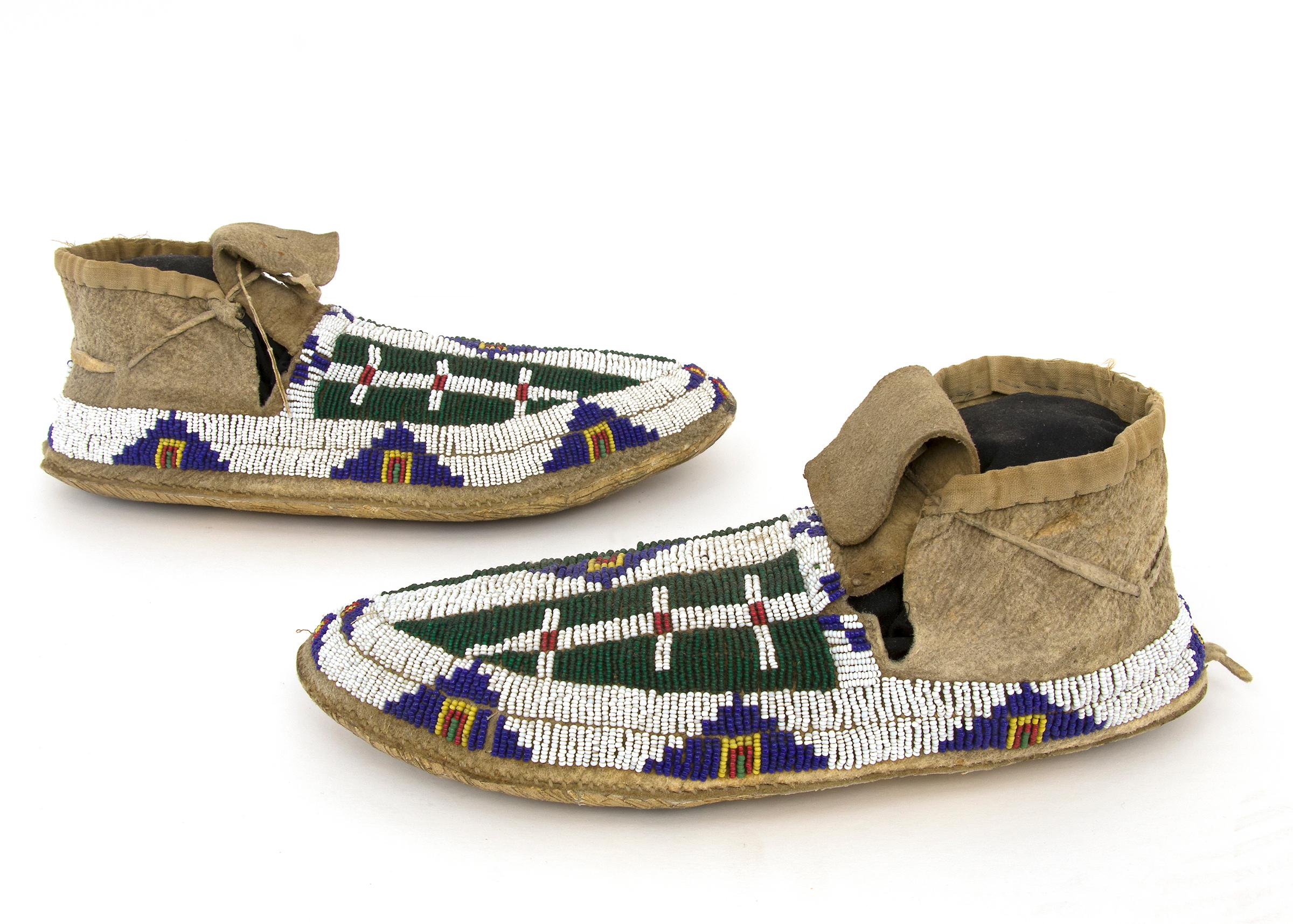 This pair of 19th century antique moccasins date to circa 1880 and are constructed of native tanned hide and sewn with glass trade beads in colors of green, white, red, blue and yellow. The primary design element of these moccasins are intricate