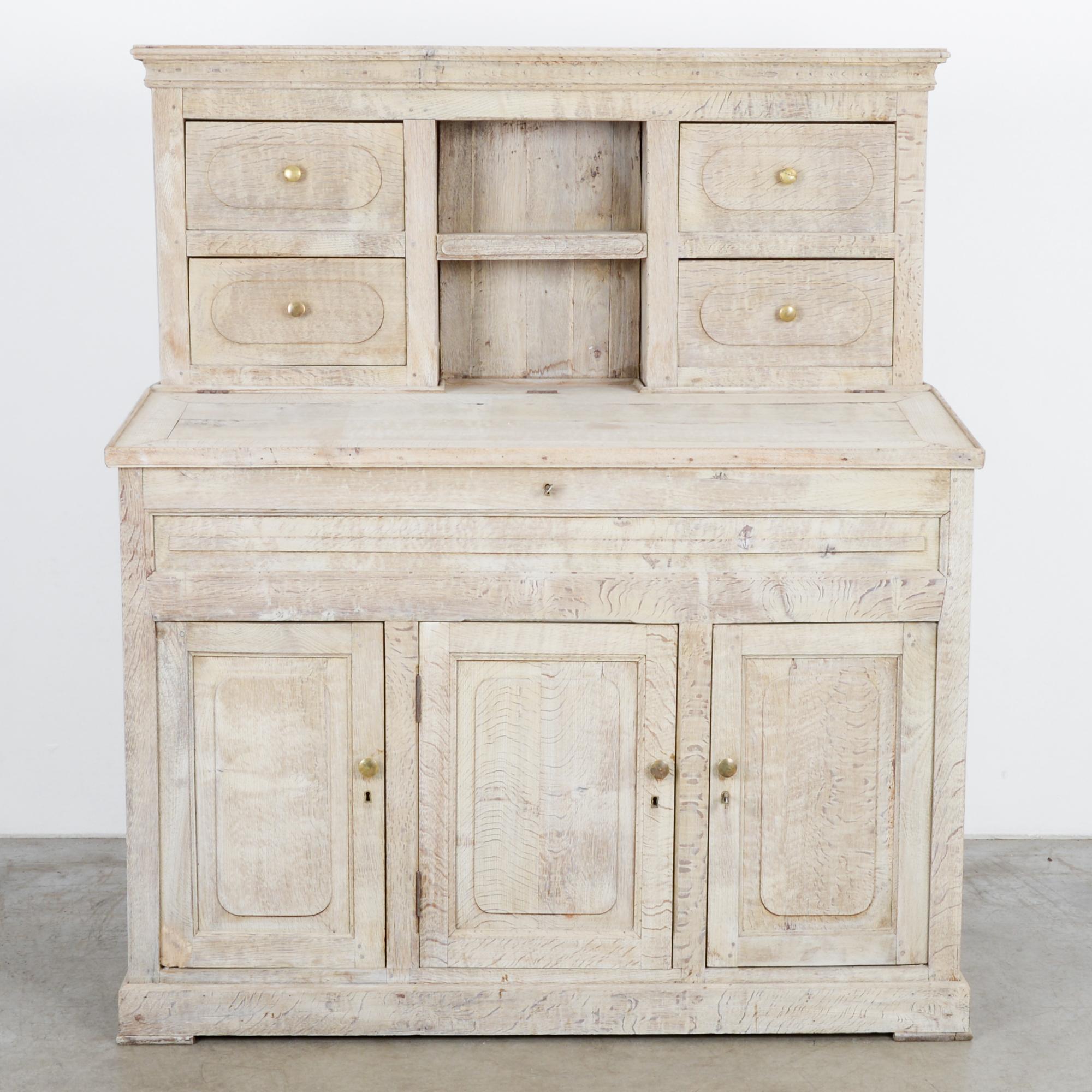 This oak secretary cabinet was made in Belgium, circa 1880. The top section features four drawers and shelves in the middle. Additional shelves at the bottom provide additional storage space. The impressive workmanship can be seen in the sturdy