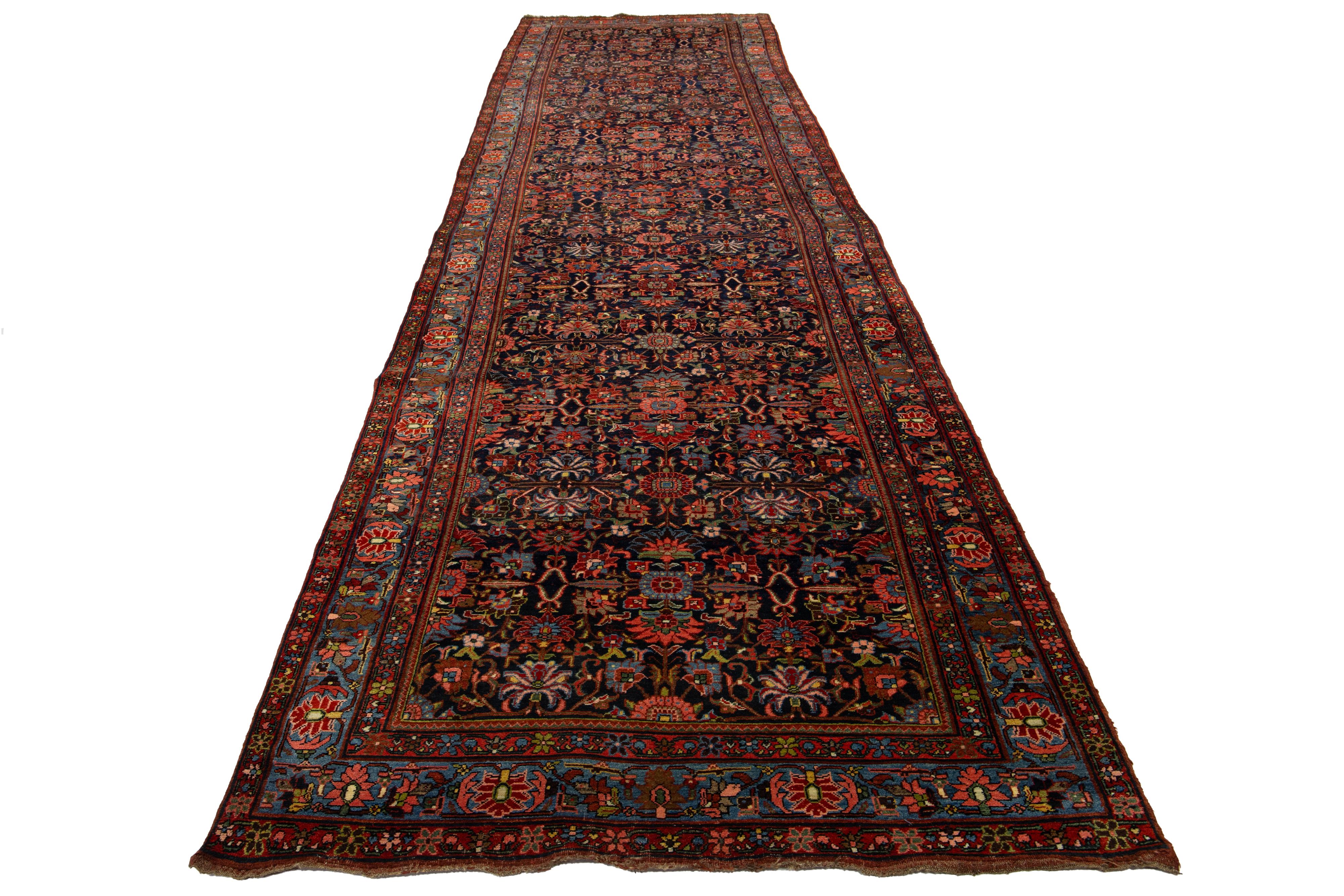 Cet exceptionnel tapis persan ancien en laine Bidjar est une véritable pièce d'apparat qui respire le charme et le caractère. Confectionné en laine impeccable nouée à la main, son champ bleu foncé saisissant met en valeur un motif floral vibrant,