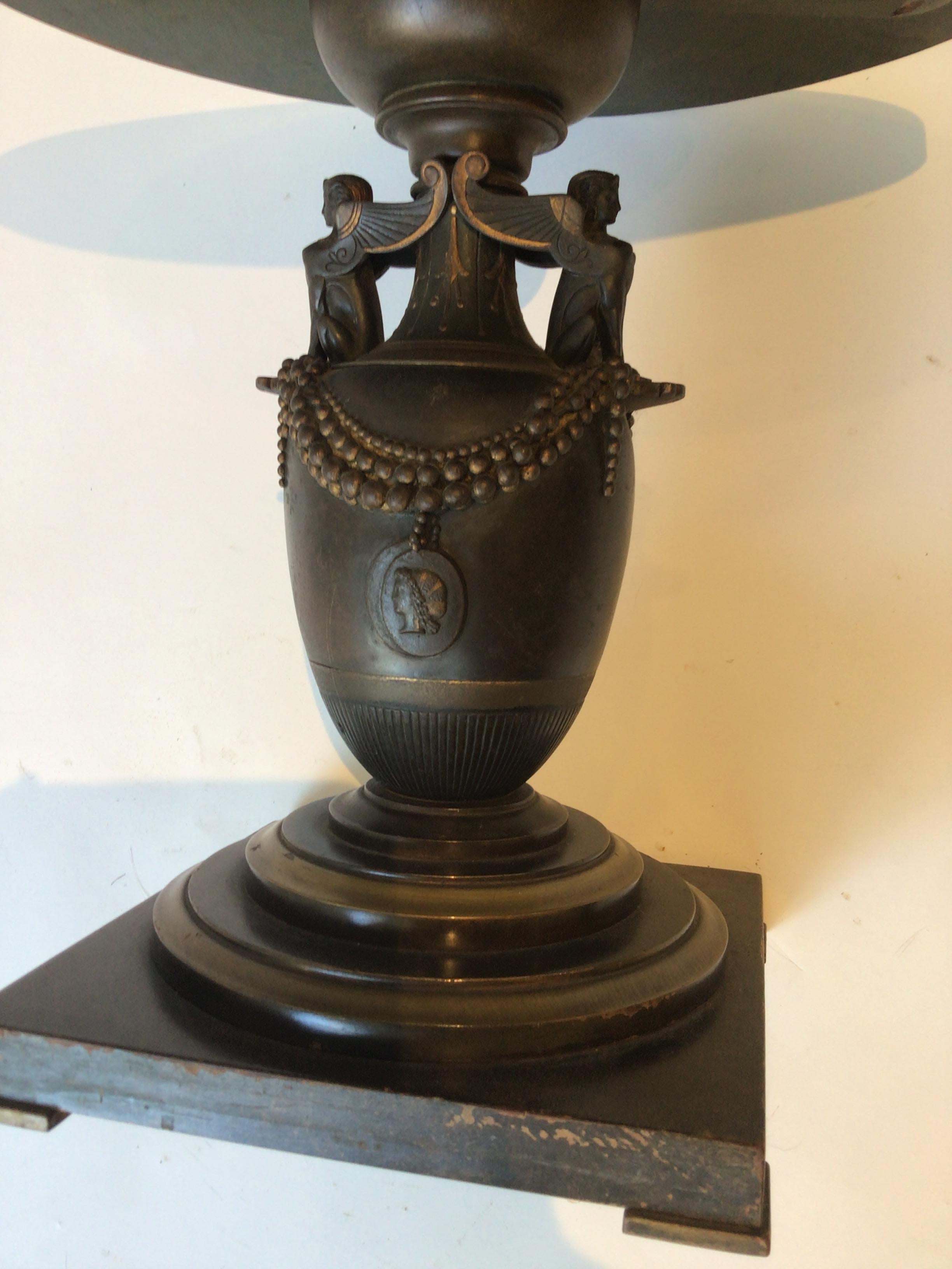 1880s Bronze classical urn made into a side table in the 1950s. Wood base and top.