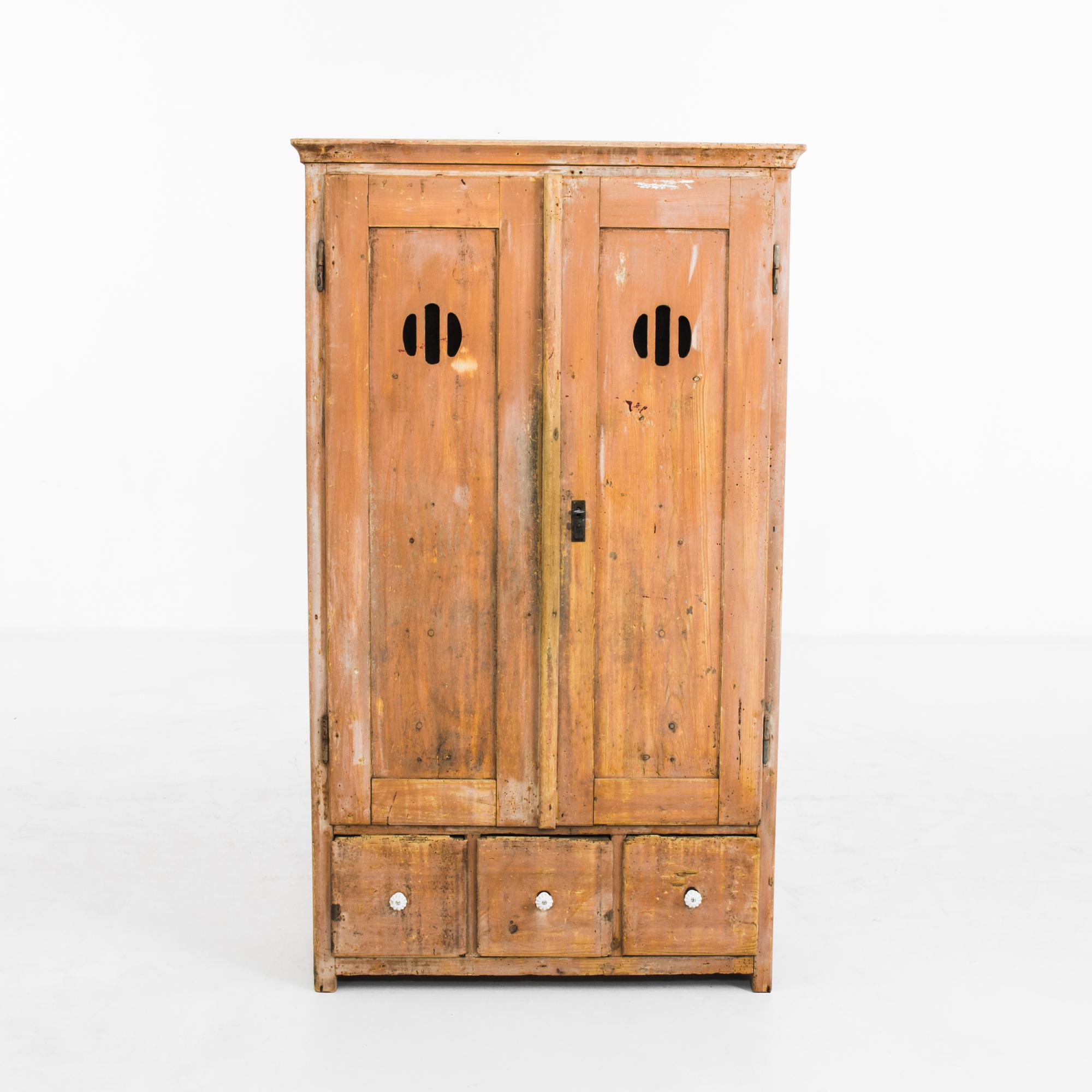 A wooden cabinet from 1880s Czechia. The warm russet tone of the case is countered by the vivid patinated blue of the interior, creating a lively color palette. Circular vents on the front of the doors indicate that the cabinet would have originally