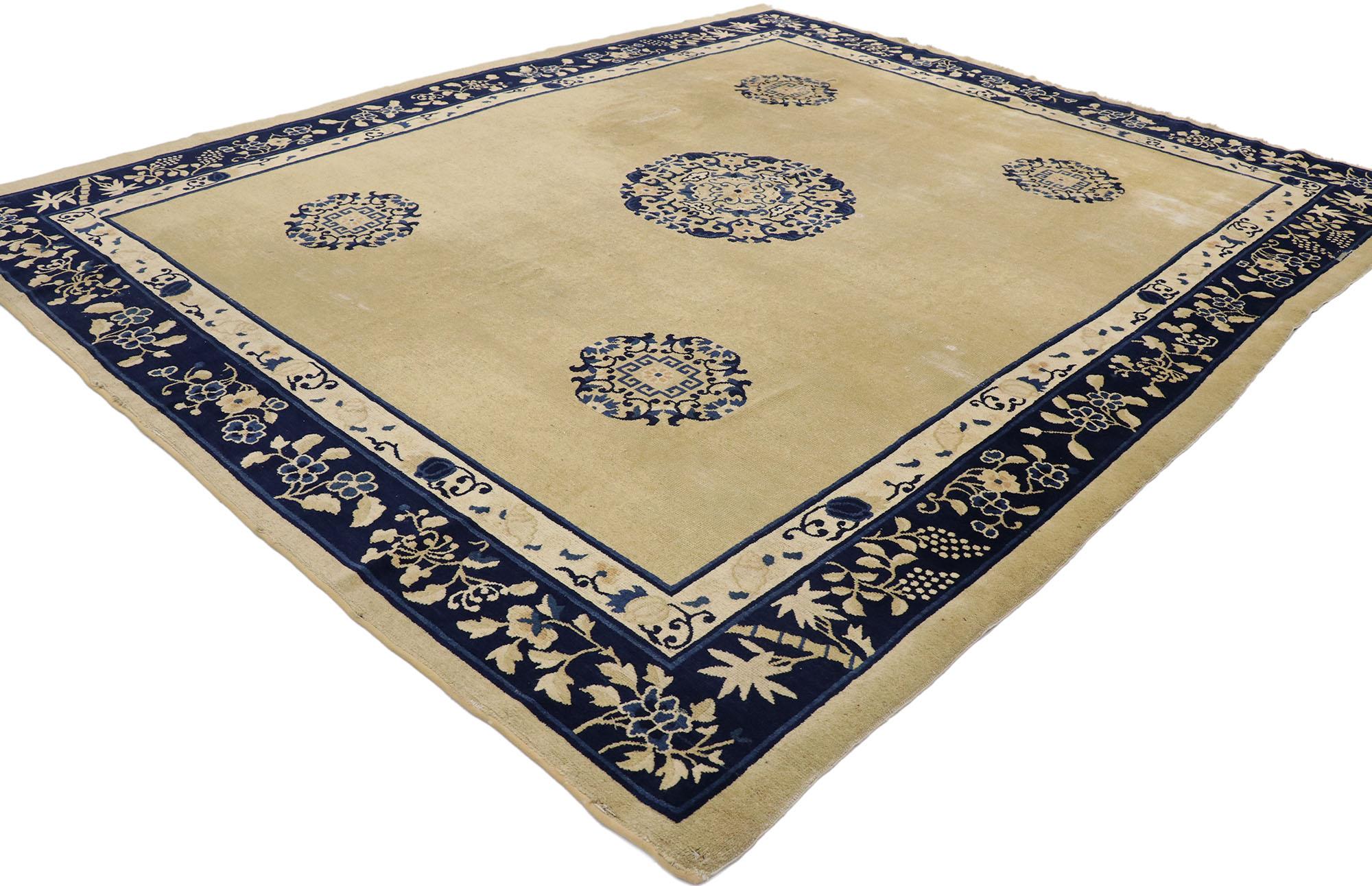77562, 1880s distressed antique Chinese Peking rug with Classic Victorian style. This hand knotted wool distressed antique Chinese Peking rug features a rounded open center medallion and four corner medallions floating on an abrashed cream field.