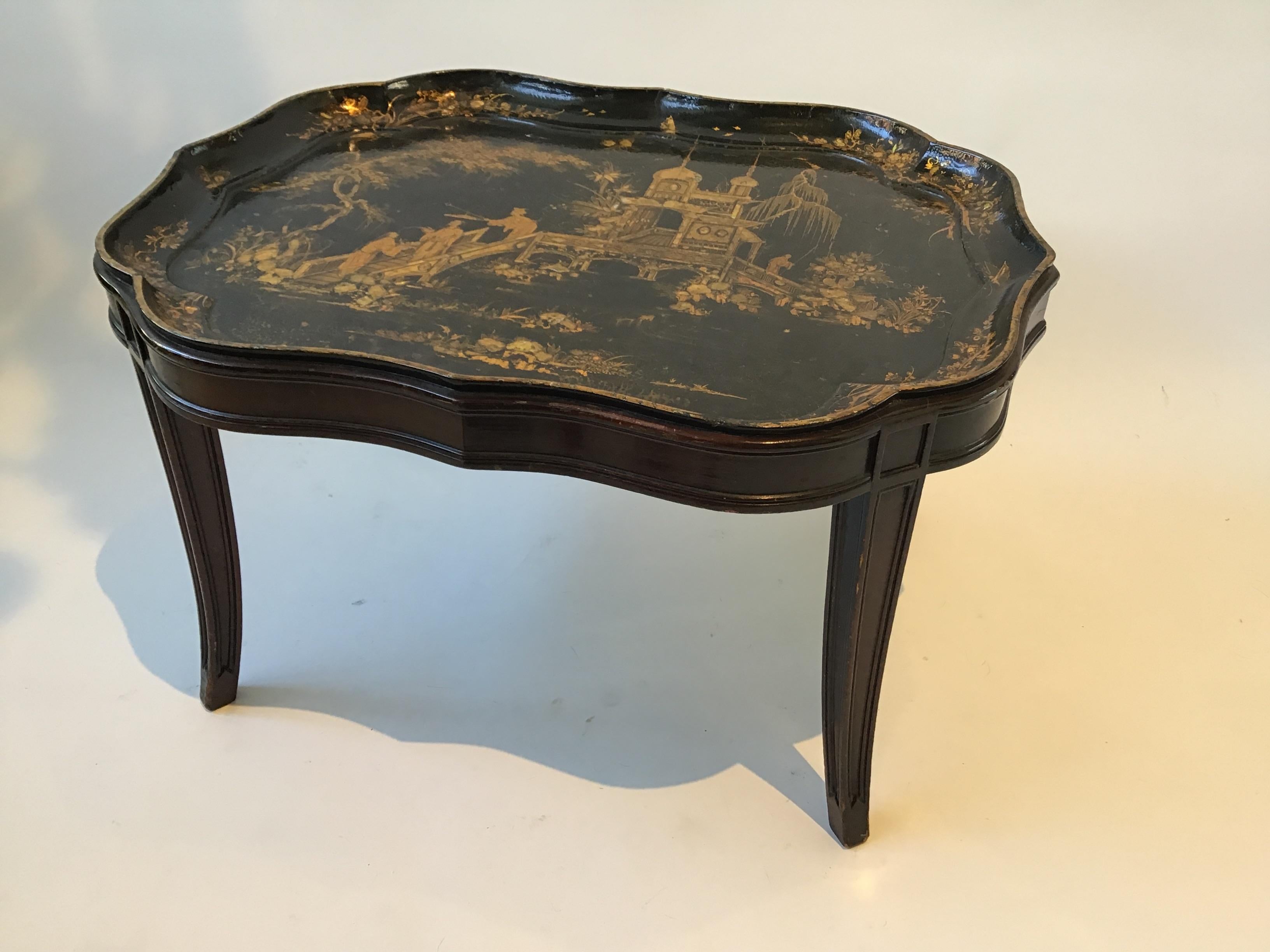 1880s English chinoiserie paper mache tray table. Hand painted tray with mother of Pearl on a custom made base. Looks like base was made in the 1940s. 
Some chips in the lacquer finish. There’s a ring on the tray as seen in image 4.