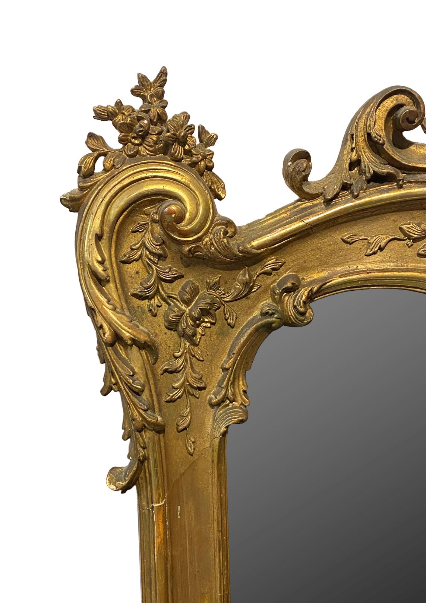 1880s French highly hand carved decorative giltwood framed beveled mirror. Minor losses of gesso and carved pieces.