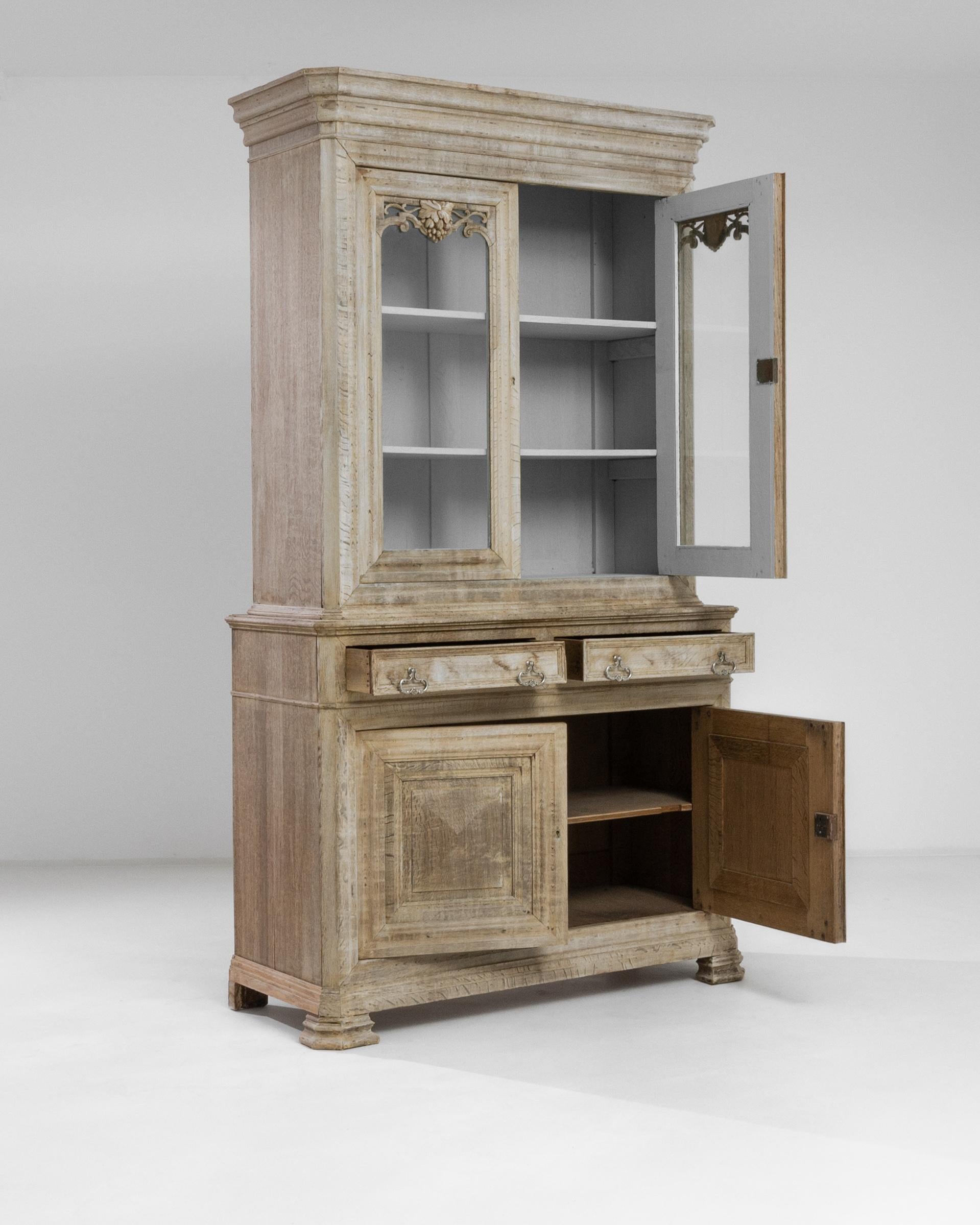 Step back in time with this exquisite 1880s French Bleached Oak Vitrine, a piece that exudes classic elegance and storied charm. The vitrine, crafted during the late 19th century, stands as a testament to timeless French craftsmanship. Its