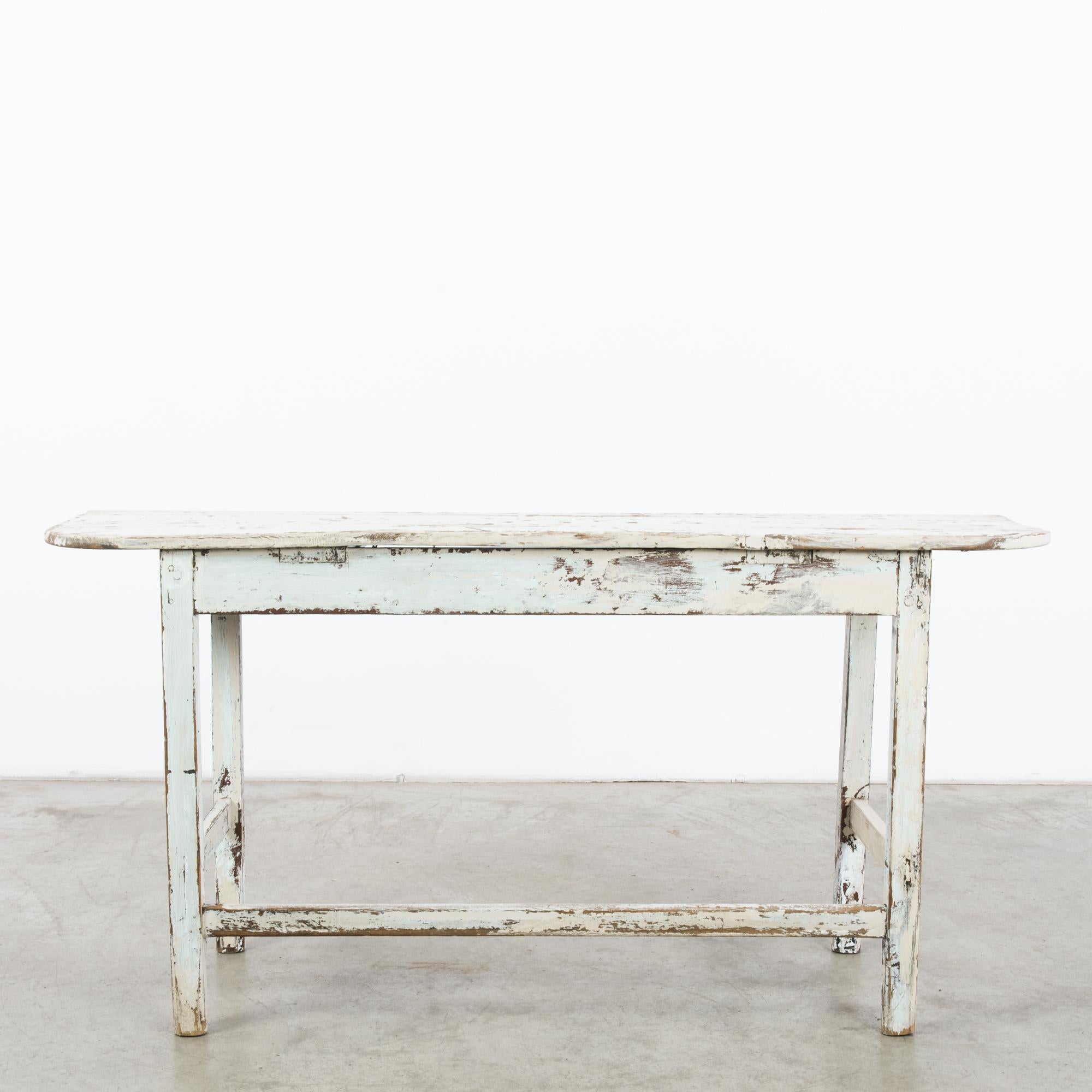 This wooden console table with rounded edges was made in France, circa 1880. Its simple construction features three stretchers and four angular posts with a slight taper toward the ground. Exquisitely weathered, the cream and soft sky blue patina