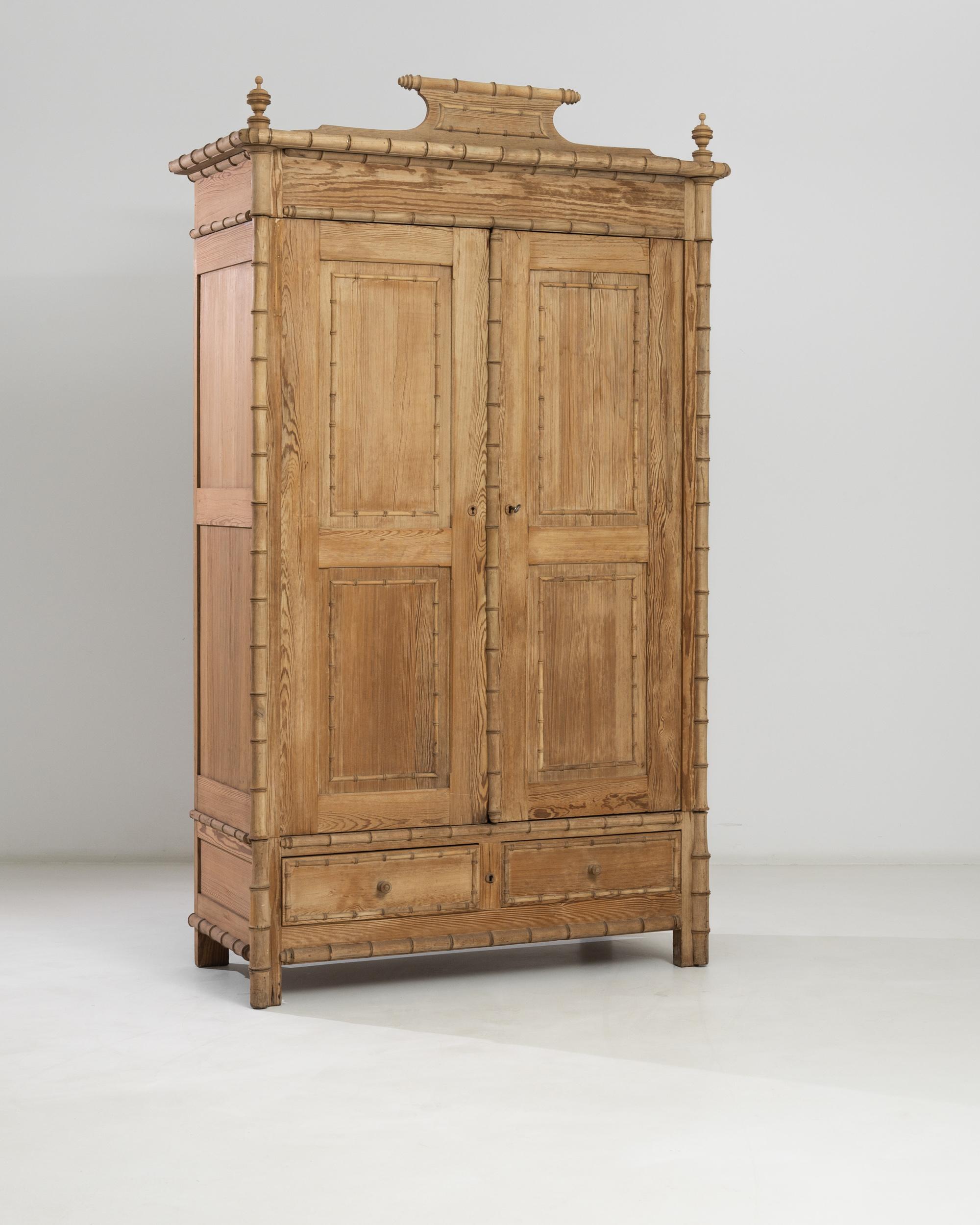 A spacious wooden cabinet made in France circa 1880. Distinct faux bamboo framing follows the contour of the chest, punctuating the strong geometric outlines of the square front feet and molded top adorned with an oriental wooden tiara and