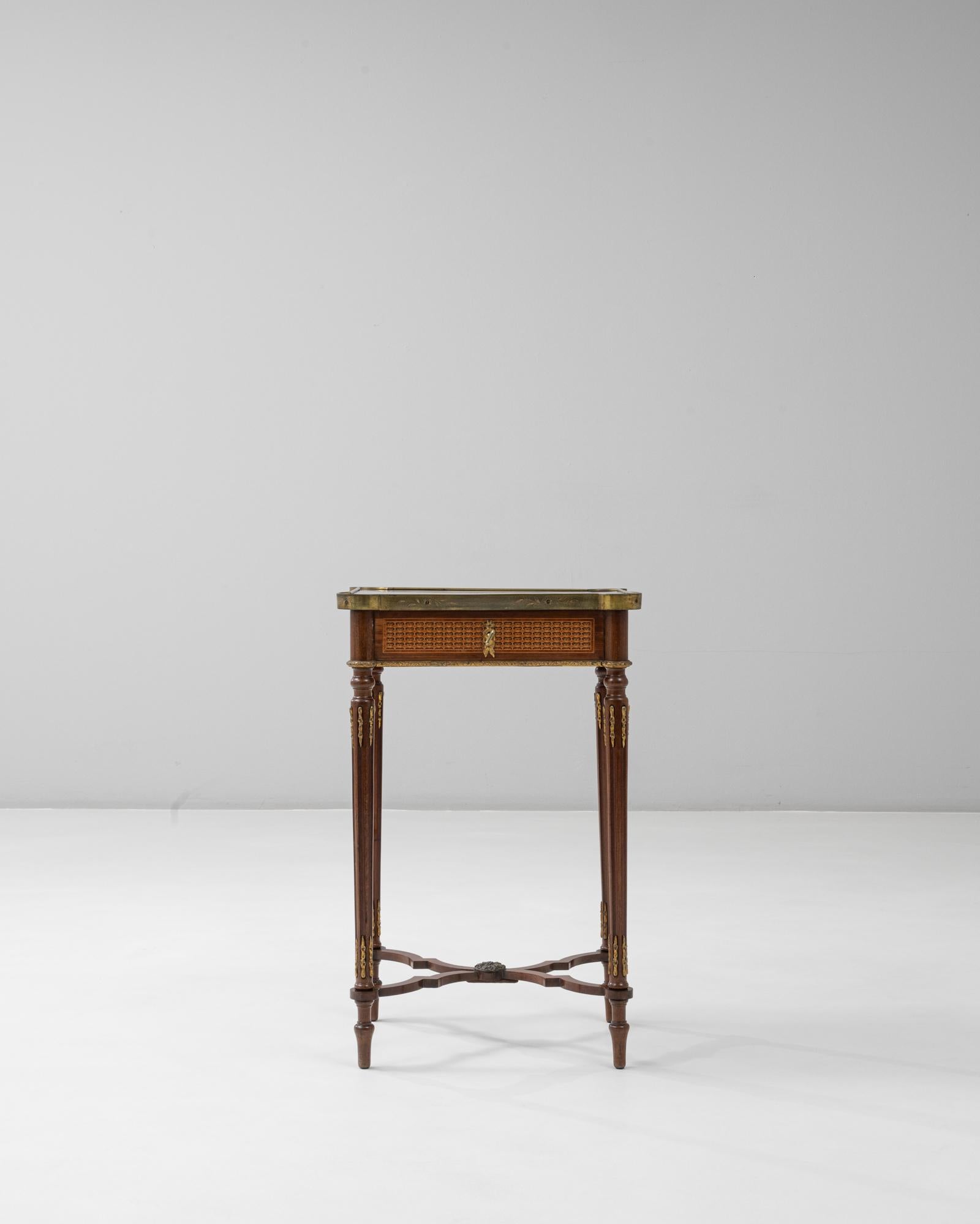 This exquisite 1880s French Louis XVI style side table is finely crafted with remarkable marquetry and elegant gilt bronze details. The rectangular top features an intricate inlay of floral and neoclassical motifs, framed by a brass gallery with