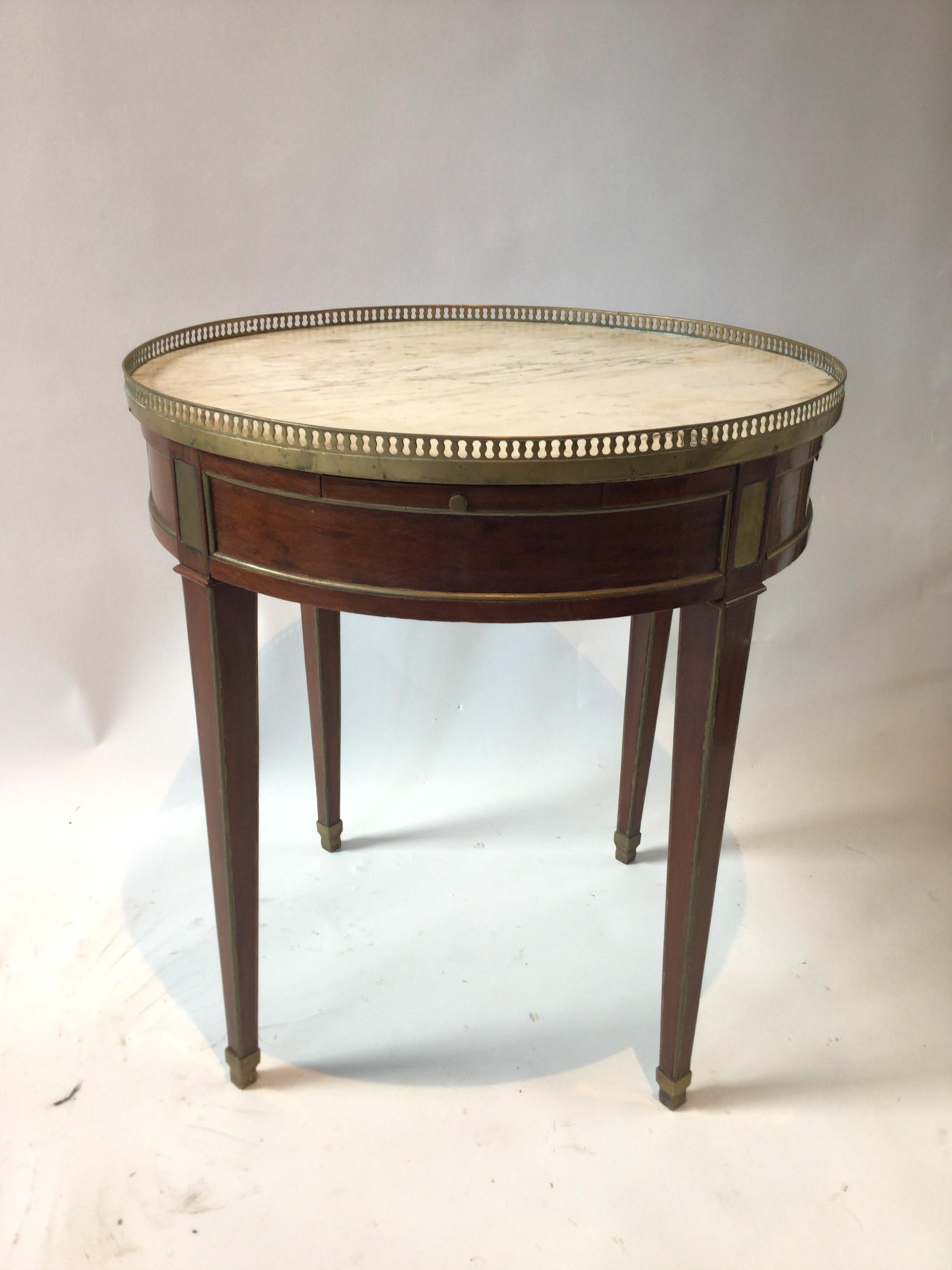 1880s French marble top side table with brass accents. There’s a crack the length of the marble as seen in image 4. The marble is secure and tight.