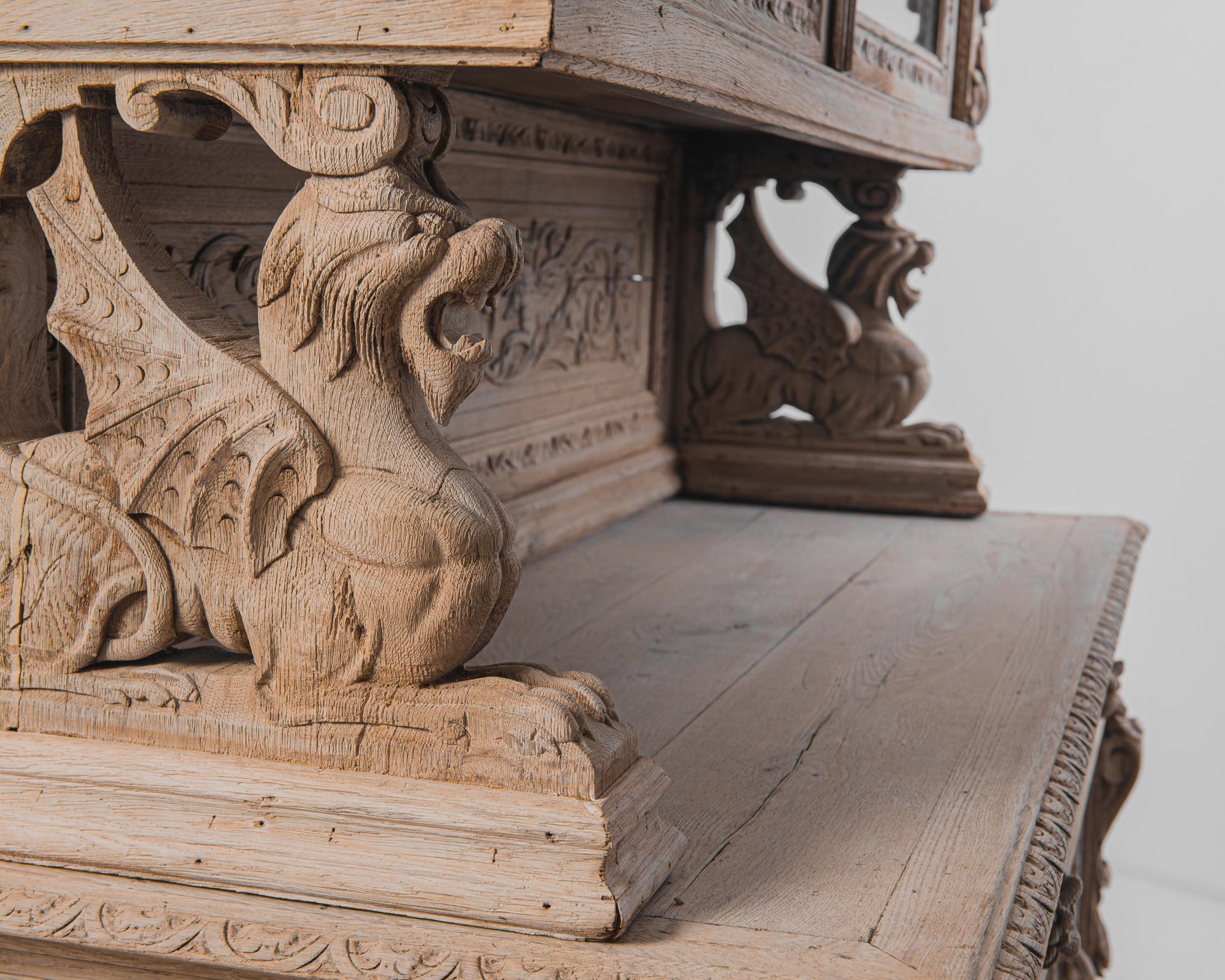 Lavish carving gives this 1880s French vitrine a verdant Renaissance feel. Scrolling leaves, and vines, fruit and flowers, carved in exquisite detail, cover every surface of the case. Carved dragons set on top of the lower cabinet support the
