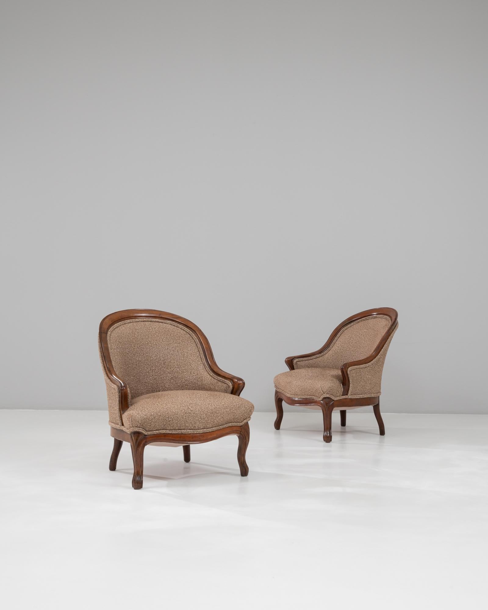 This elegant pair of Louis Philippe bergère chairs from 1880s France embodies the refined craftsmanship and comfort typical of the period. Each chair features a deeply curved walnut frame with smooth, flowing lines that emphasize the graceful