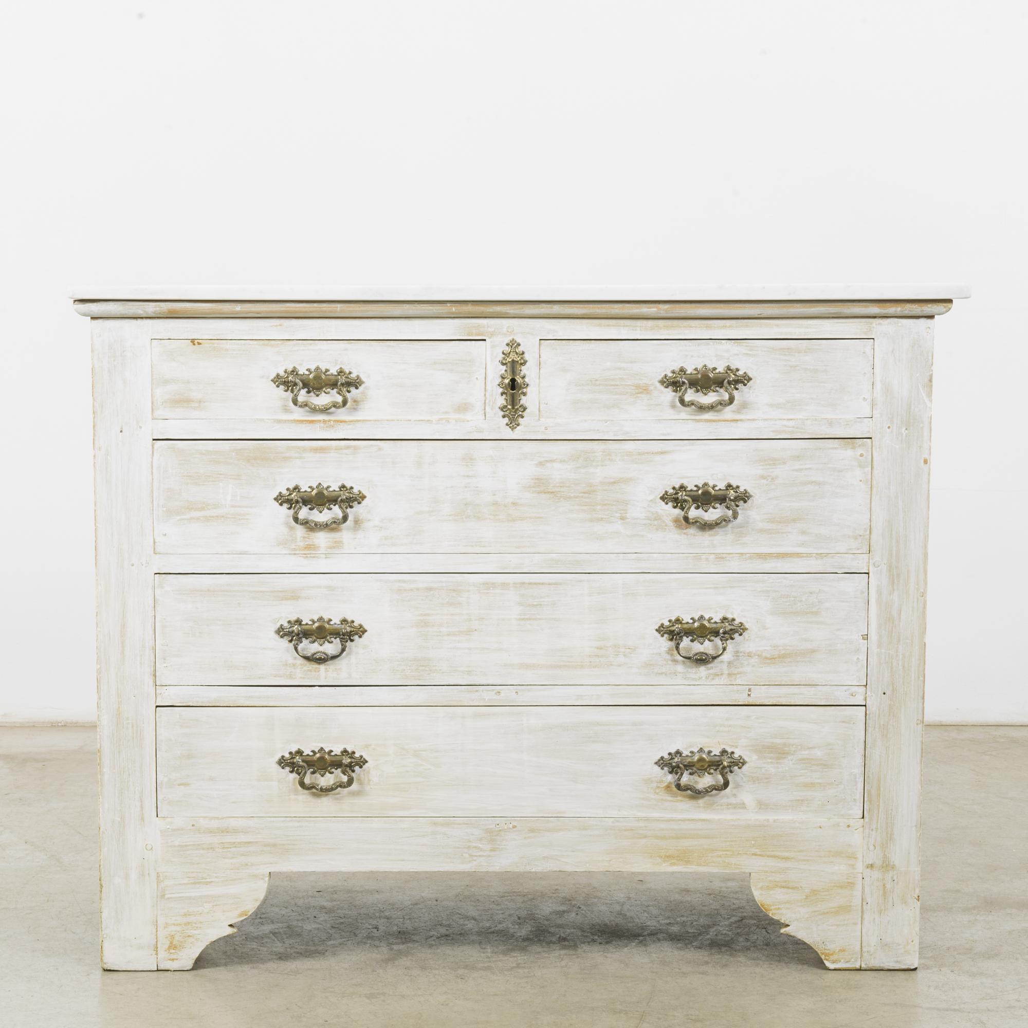This wooden chest of drawers with a white marble top was made in France, circa 1880. The geometric silhouette is adorned simply with bracket feet and a shaped base on the sides, giving this piece a calm and stately appearance. With a beautifully