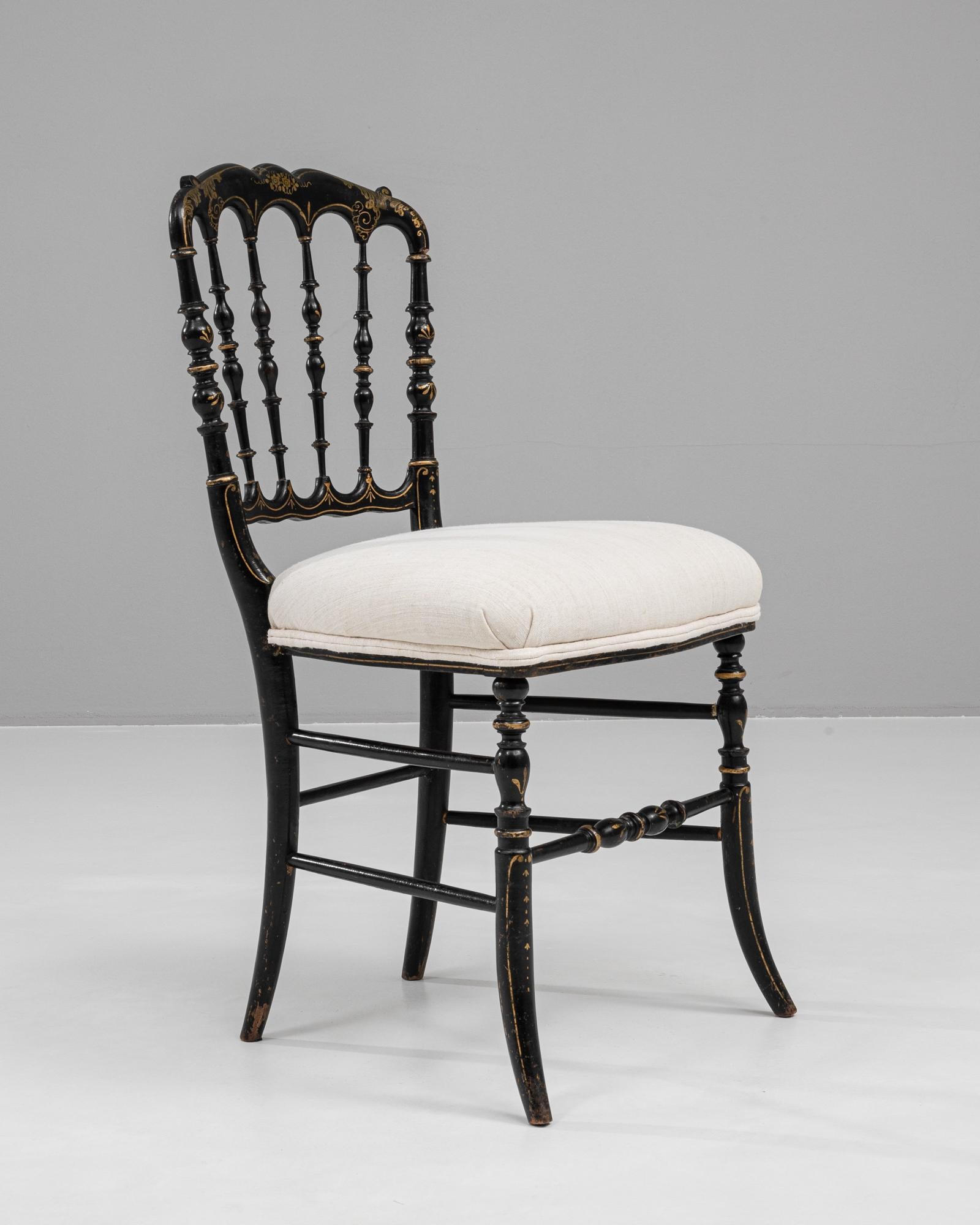 Questa sedia francese in legno del 1880 è una testimonianza dell'eleganza e della maestria dell'epoca. Il suo splendido schienale curvo è impreziosito da intricati dettagli dipinti a mano in oro, che sottolineano la raffinatezza del suo design. La