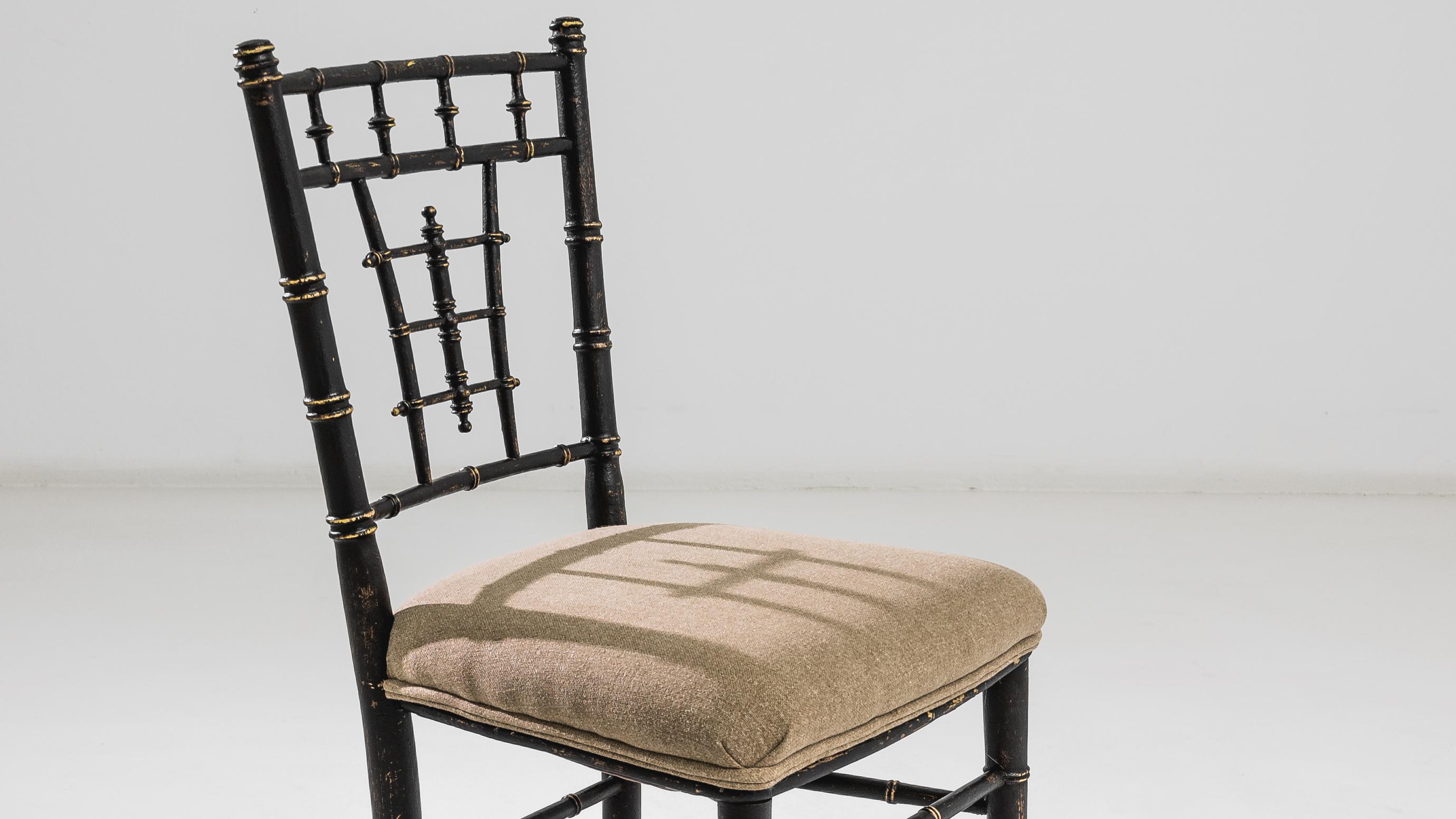 Elevate your dining experience with this exquisite 1880s French Wooden Dining Chair, a charming chair that seamlessly blends comfort and sophistication. The chair features a classic black wooden base, which provides a striking contrast to the