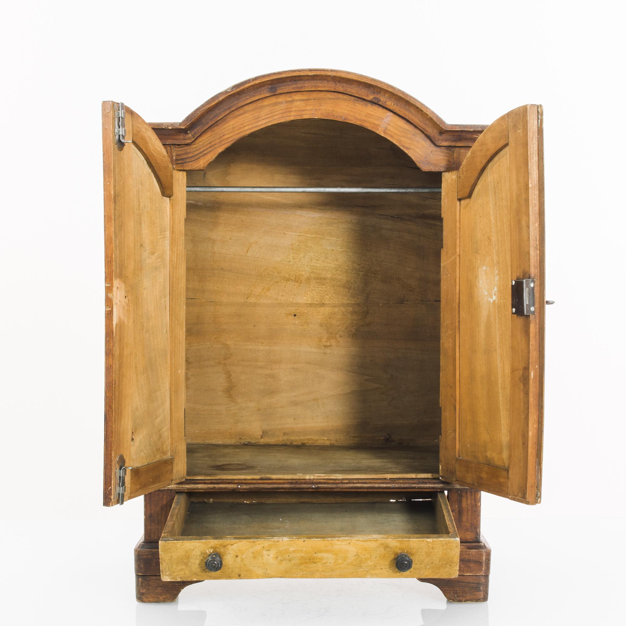 Transport your space to the refined elegance of the 1880s with this French wooden small cabinet. The two main doors swing open, revealing an open storage space equipped with a metal bar, perfect for hanging your clothing collection. A convenient