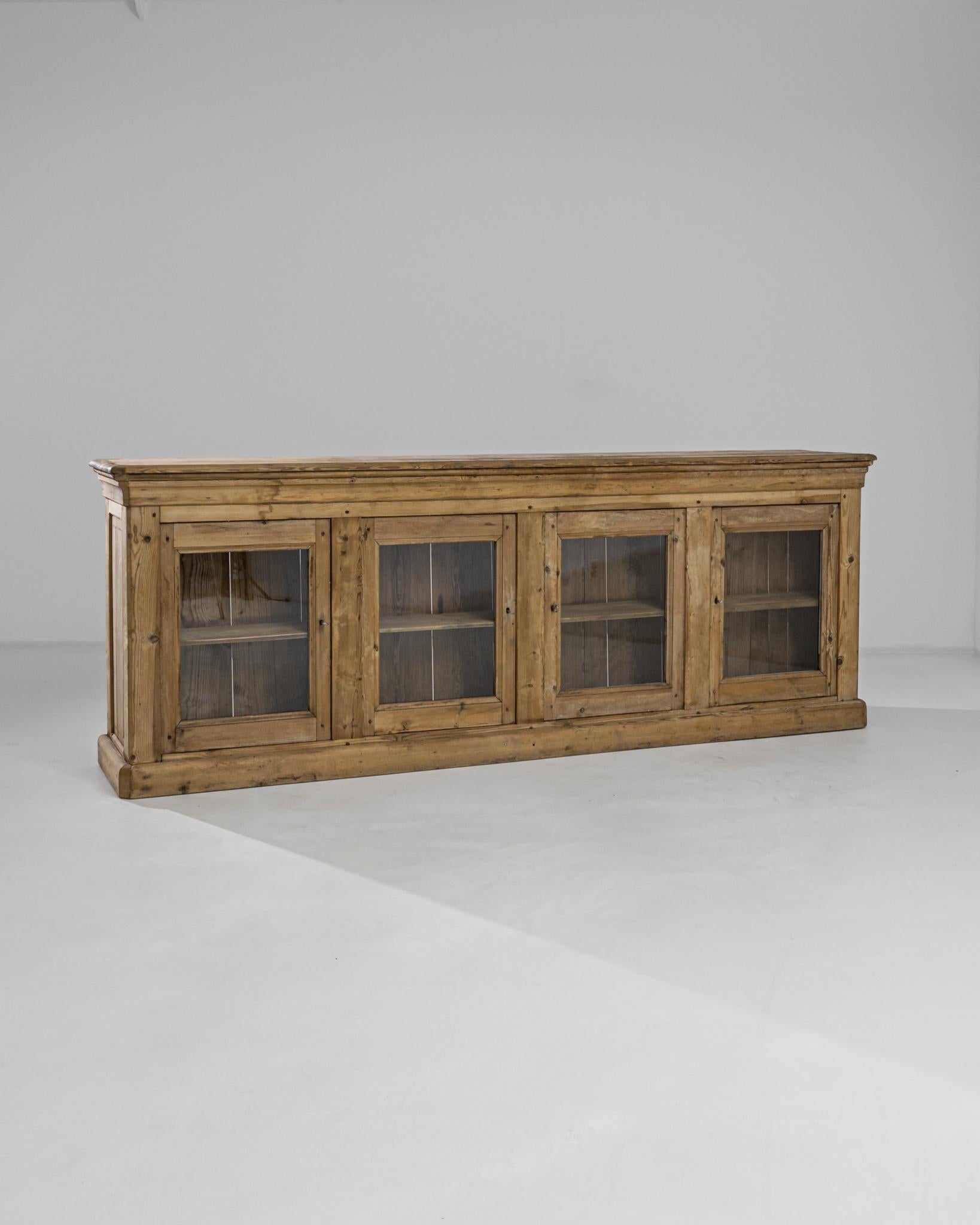 This horizontal vitrine was produced in France, circa 1880. Actualized with new glass panels, this antique vitrine exhibits a beveled top and a spacious two shelves case with locks. The beautifully preserved wood displays a honeycomb shade and a
