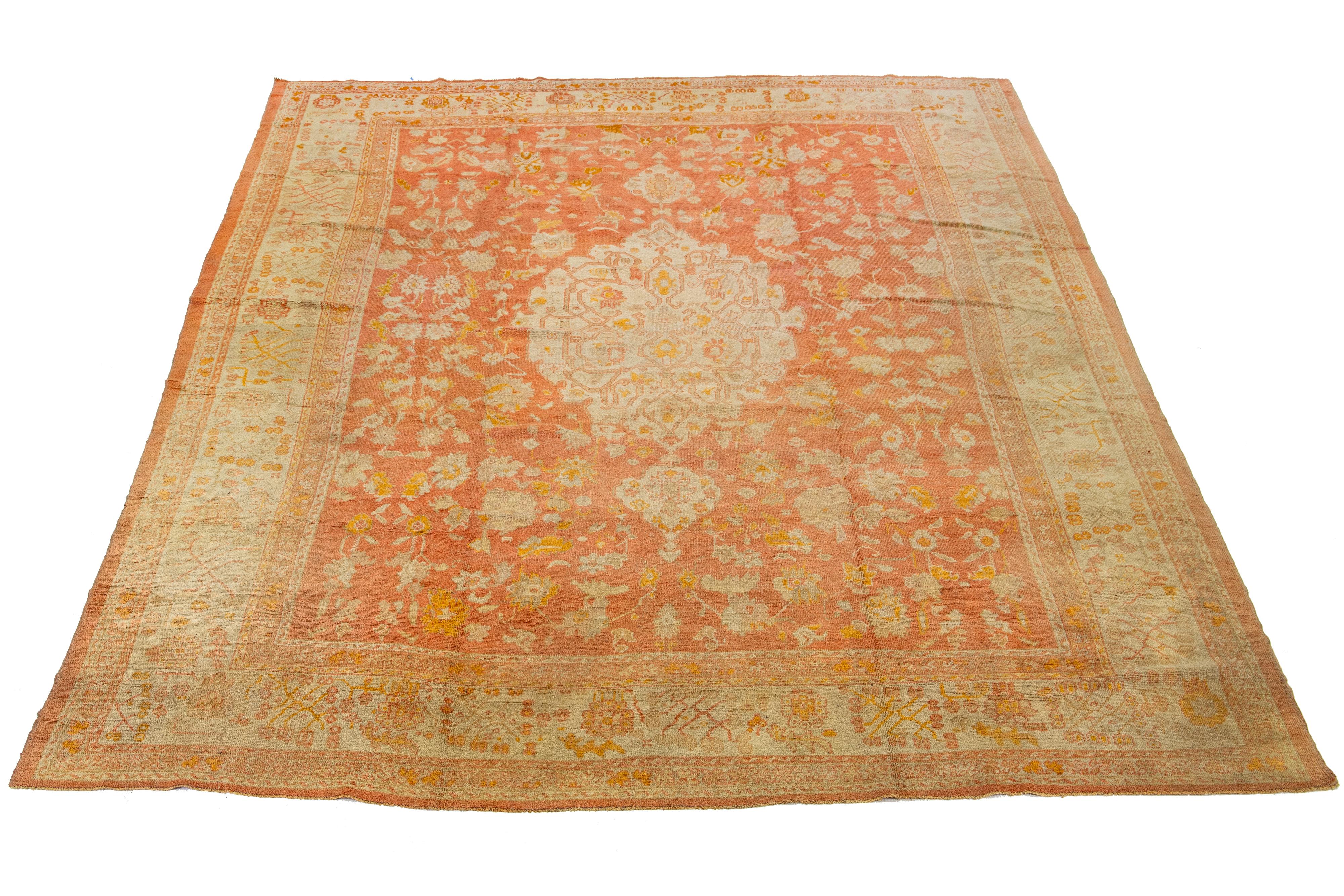 Beautiful antique Turkish Oushak hand-knotted wool rug with a light orange field and an ivory border showcasing a floral medallion motif design.

This rug measures 13'5' x 17'4