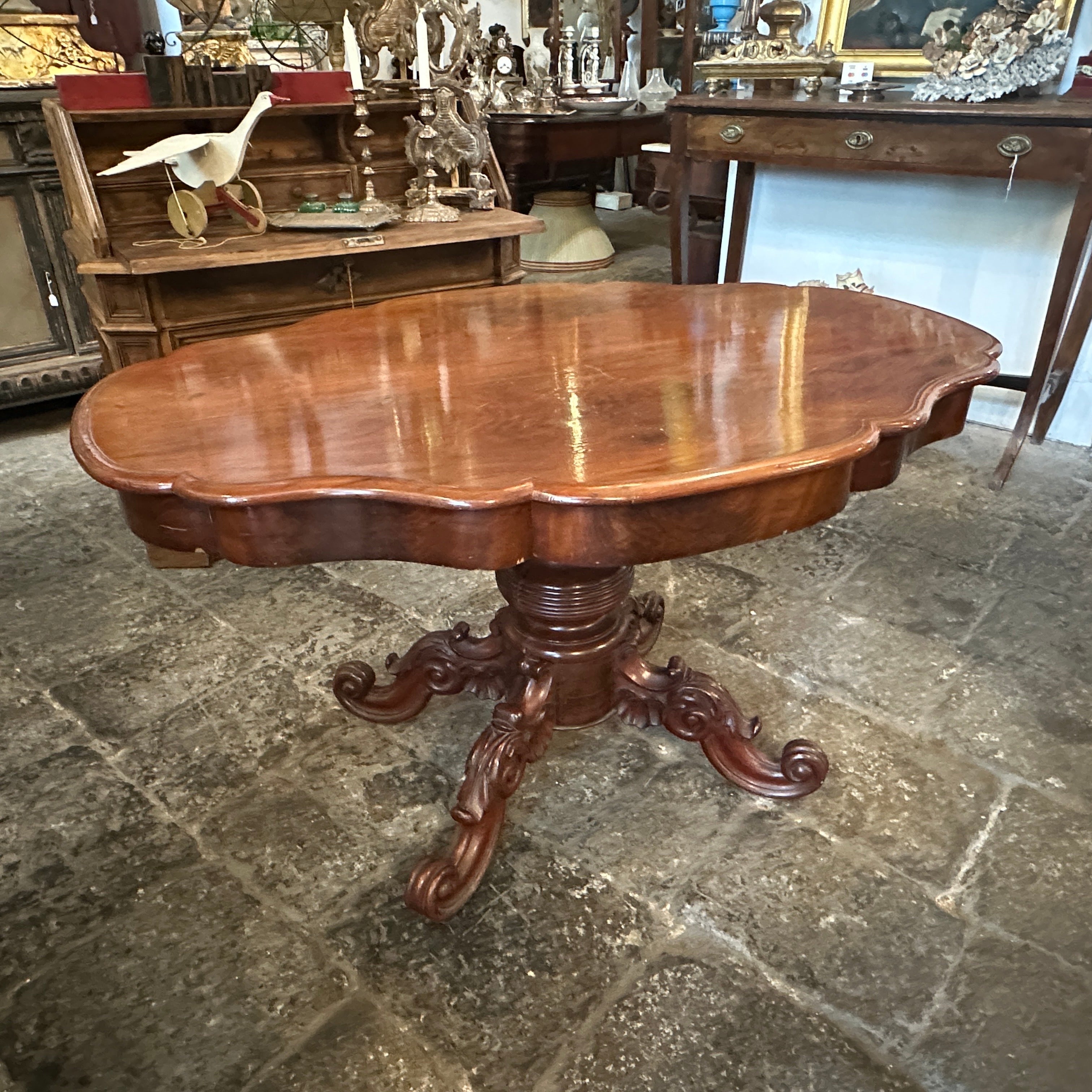  A side table crafted from mahogany, a popular hardwood during the Louis Philippe era known for its rich, dark color and fine grain. The tabletop is designed to emulate a turtle shell shape, it's in good conditions overall considering use and