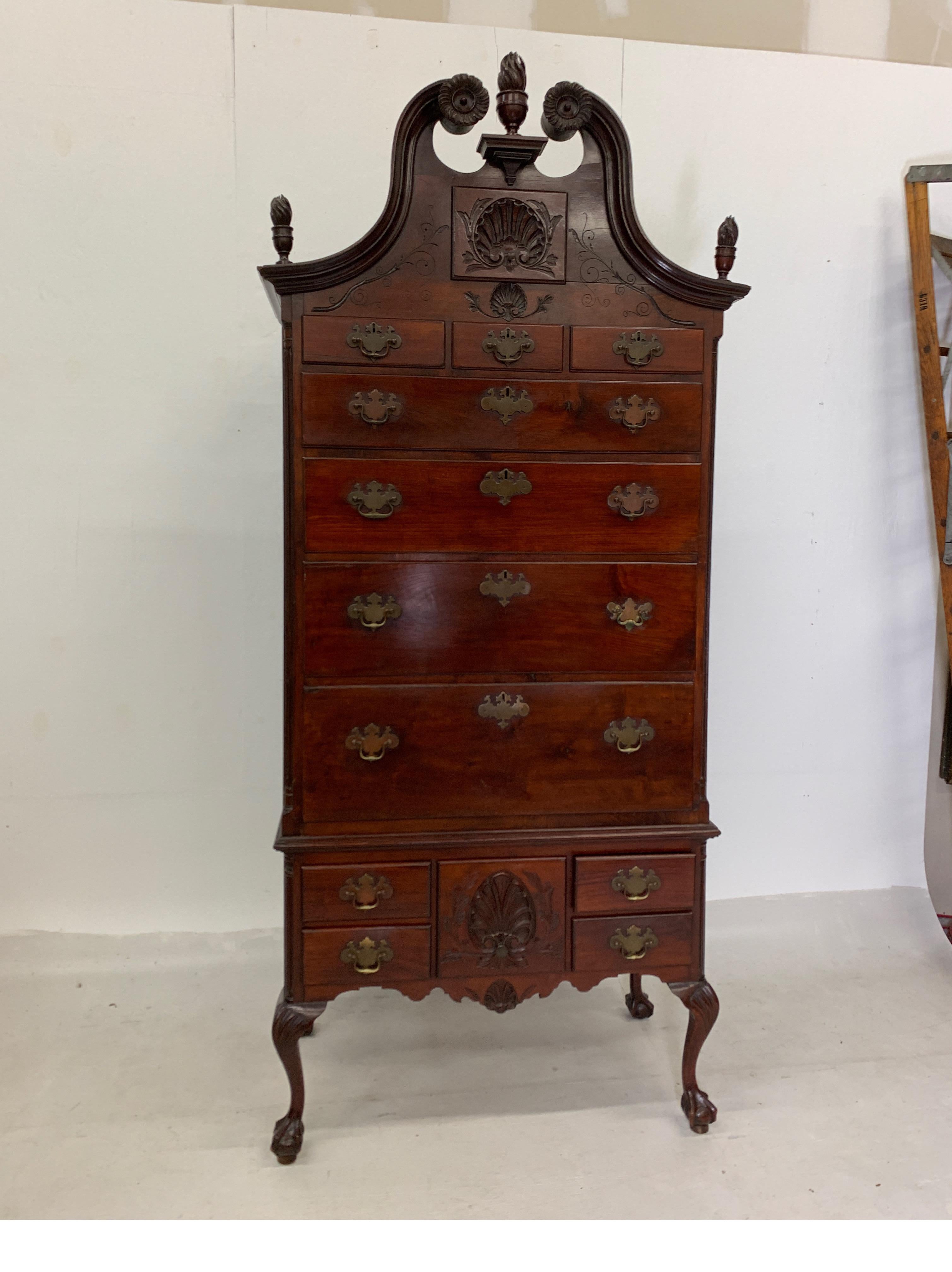 Monumental 1880s Highboy in mahogany with flame finials and cabriole legs, includes step stool. Top has three smaller drawers over four large drawers, base has five small drawers. 102