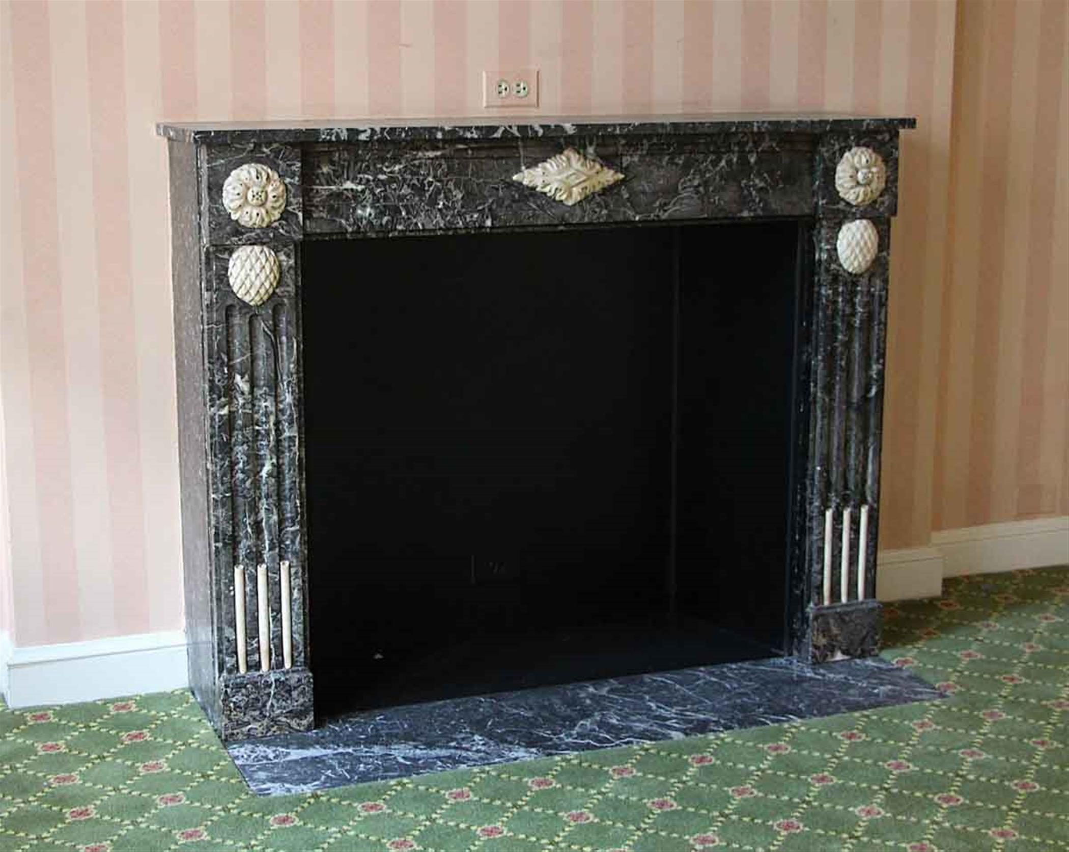 Hearth not included. French made hand carved 1880s French Regency gray marble mantel with floral detail. This mantel was one of a group of antique mantels imported from France and installed in the NYC Waldorf Astoria Hotel in 1931 when the hotel was