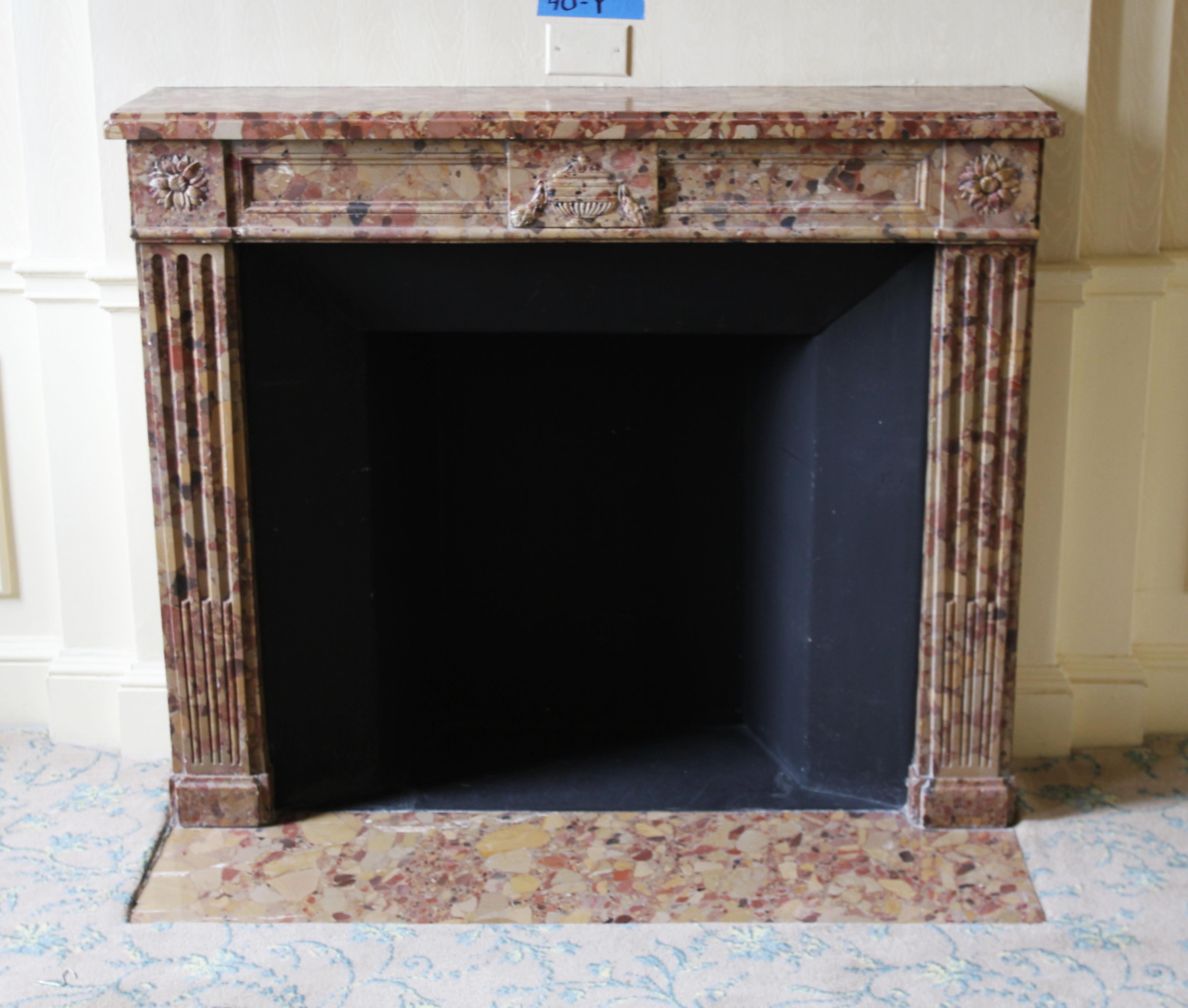 1880s yellow Breche marble mantel with gray, red and tan coloring. This mantel has pretty floral motifs on the top plinths and a carved urn in the middle of the header. This mantel was one of a group of antique mantels imported from Europe and