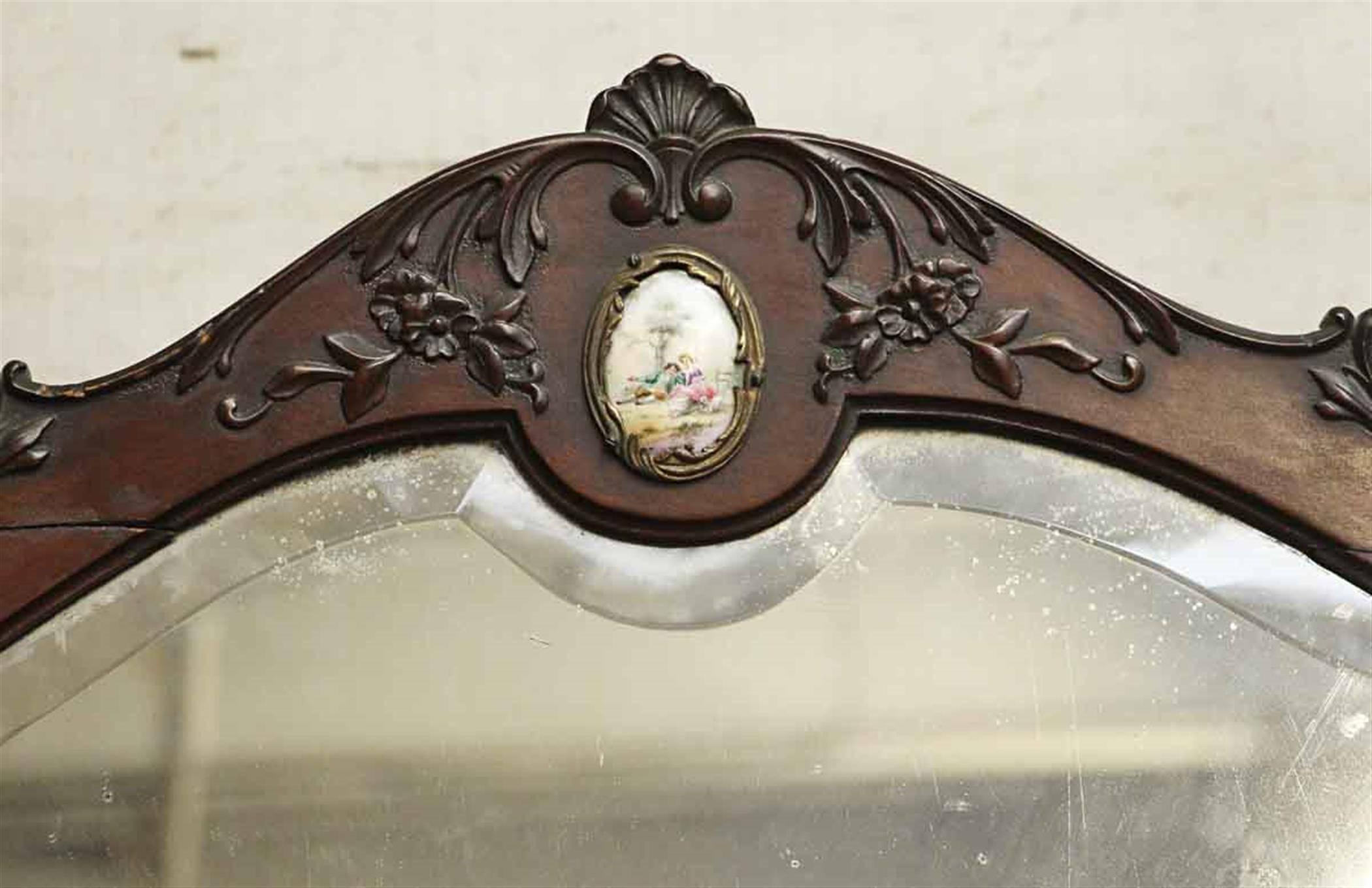 1880s beautiful Queen Anne four drawer wooden vanity with original beveled mirror and decorative figural porcelain pulls. The mirror is also adorned with a ceramic decorative detail at the top. There are two extra mini drawers on both sides at the