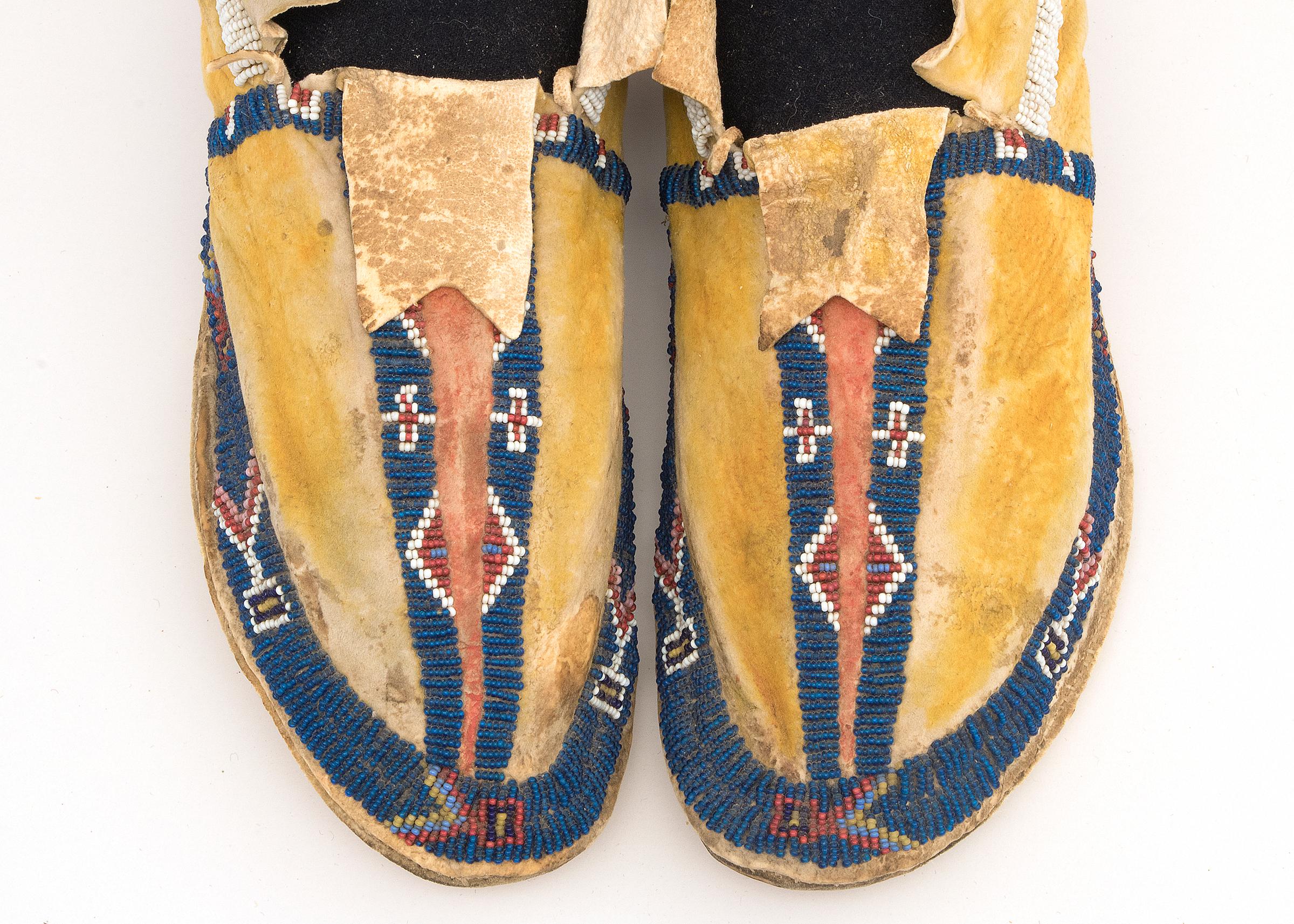 Circa 1880s Cheyenne moccasins measuring 9 ¾ x 3 x 2 ¾ inches. Decorative elements include beads and dyes in bright yellow, blue, and orange. 

 