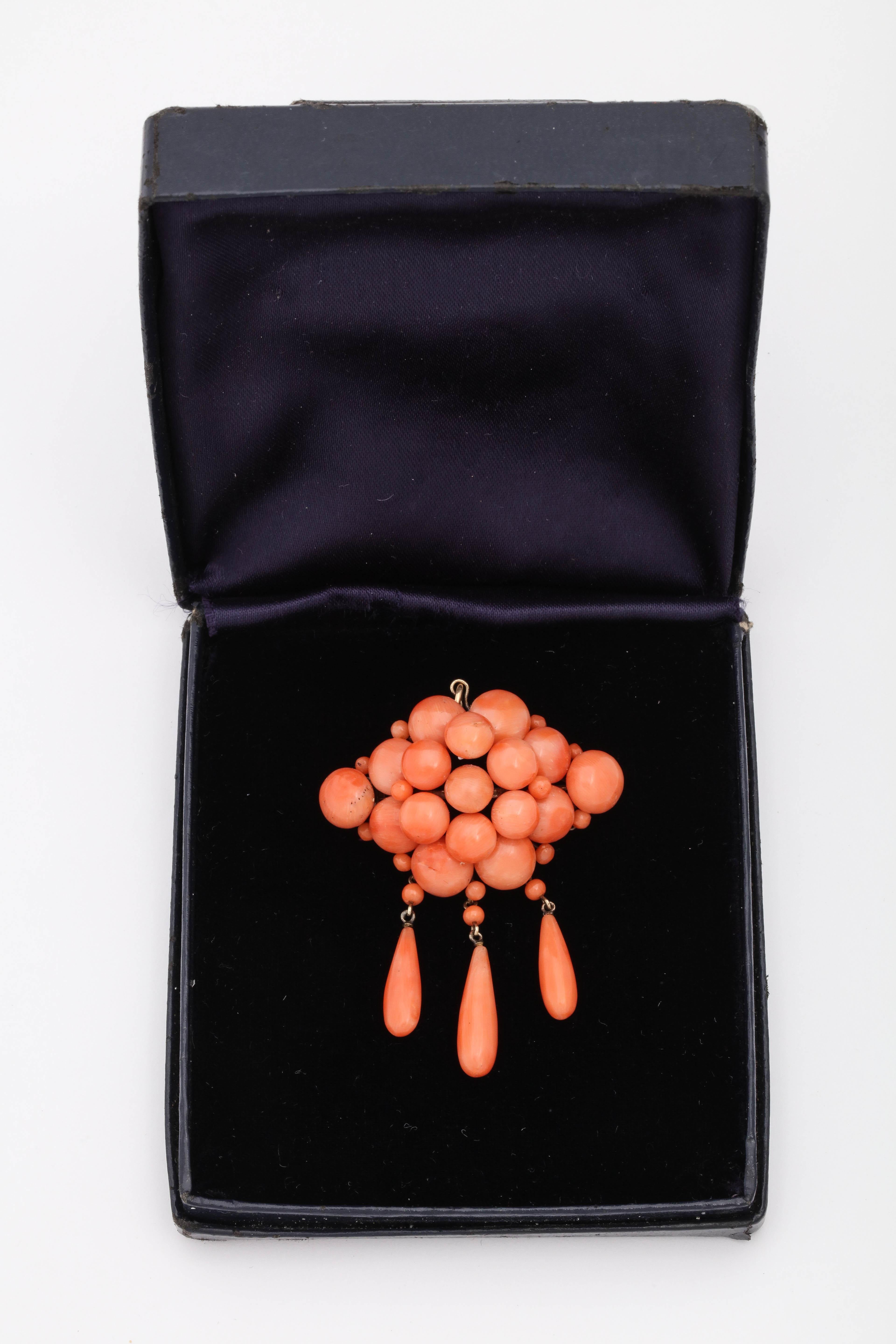 One ladies 14kt Gold Pendant And Brooch Combination Created With Numerous Button Style Corals And With Three Teardrop Shaped Dangle Corals. Created In The 1880's In The United States Of America.