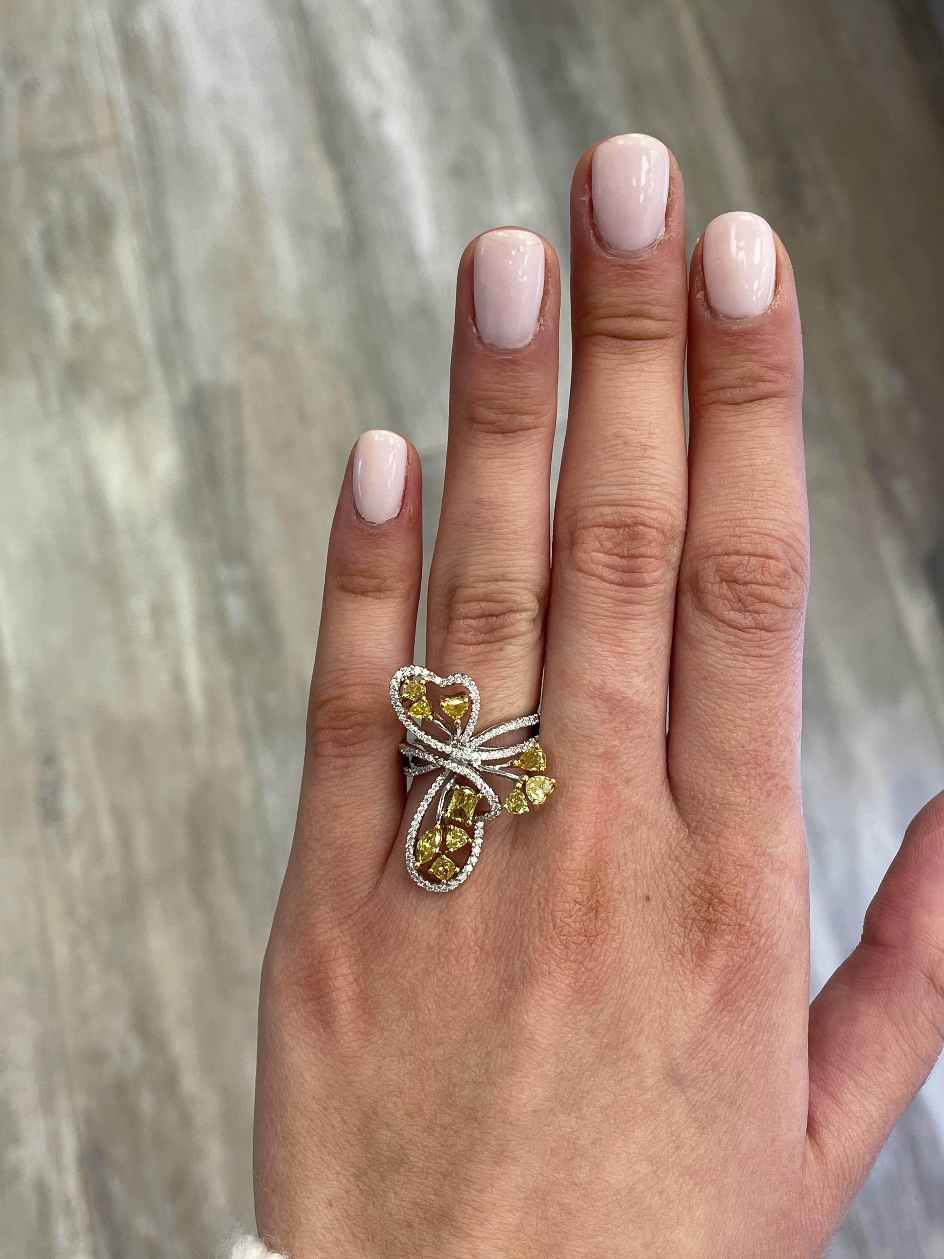 Lovely yellow diamond heart motif ring.
1.88 carats total diamond weight.
10 mixed diamonds, heart, pear, cushion, 1.33 carats. Approximately Fancy Greenish Brownish Yellow color diamonds SI clarity. Complimented by 125 round cut diamonds, 0.50