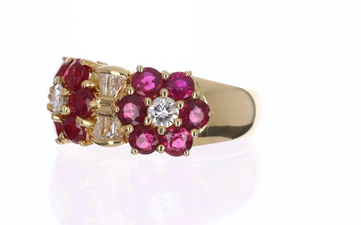 A fine quality ruby and diamond wide band in 18K yellow gold. Twelve, vivid, red rubies highlight the sides of the band and create an eye-catching design. Brilliant round and tapered baguette diamonds accent the well-designed ring. This is an